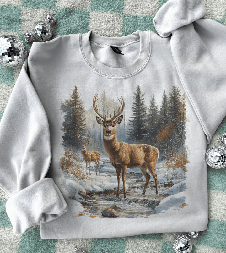 Gray sweatshirt with a deer in a forest design on a textured surface.