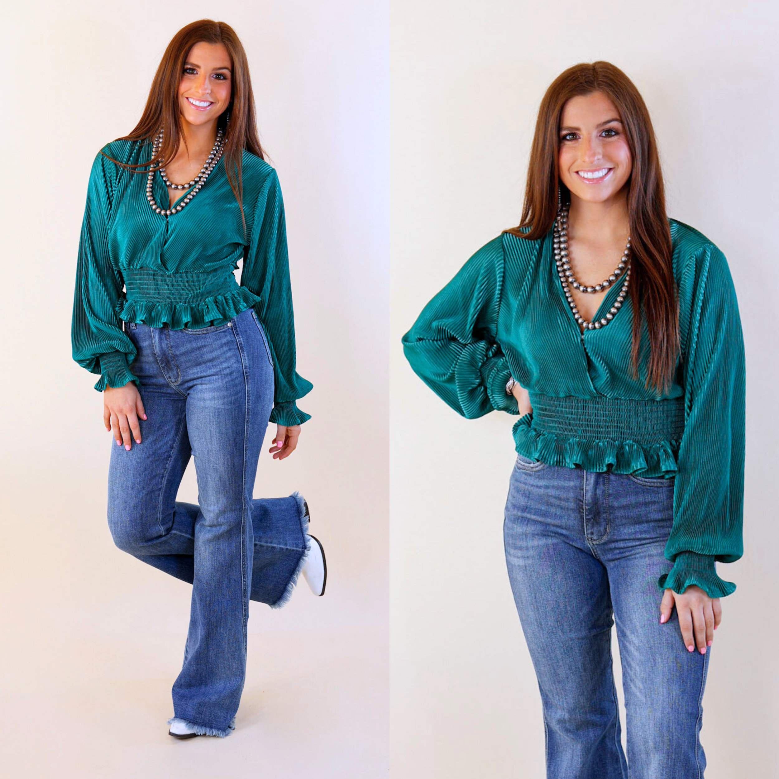 Model is wearing a satin pleated long sleeve paired with blue jeans, white booties, and silver jewelry.