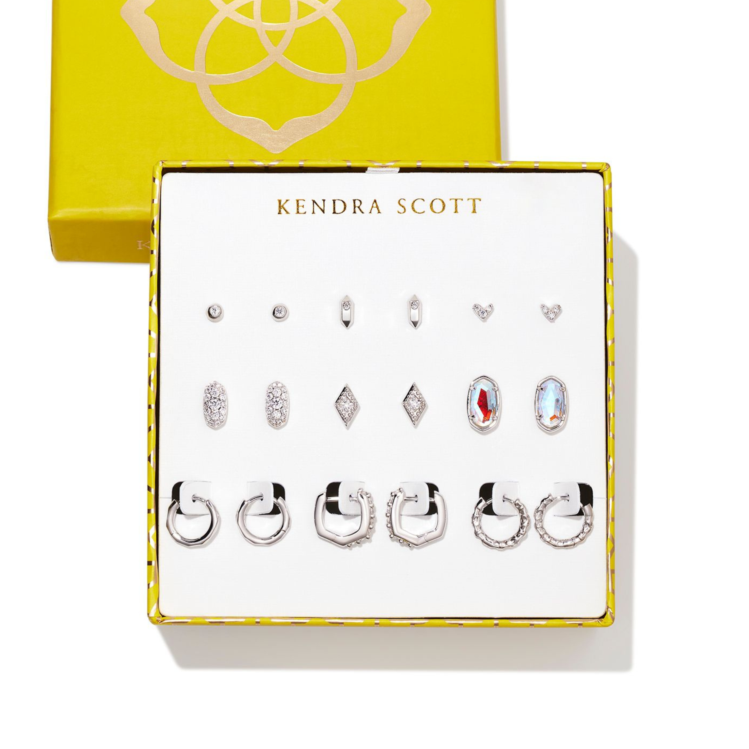 Set of nine silver earrings pictured in a Kendra Scott box on a white background.