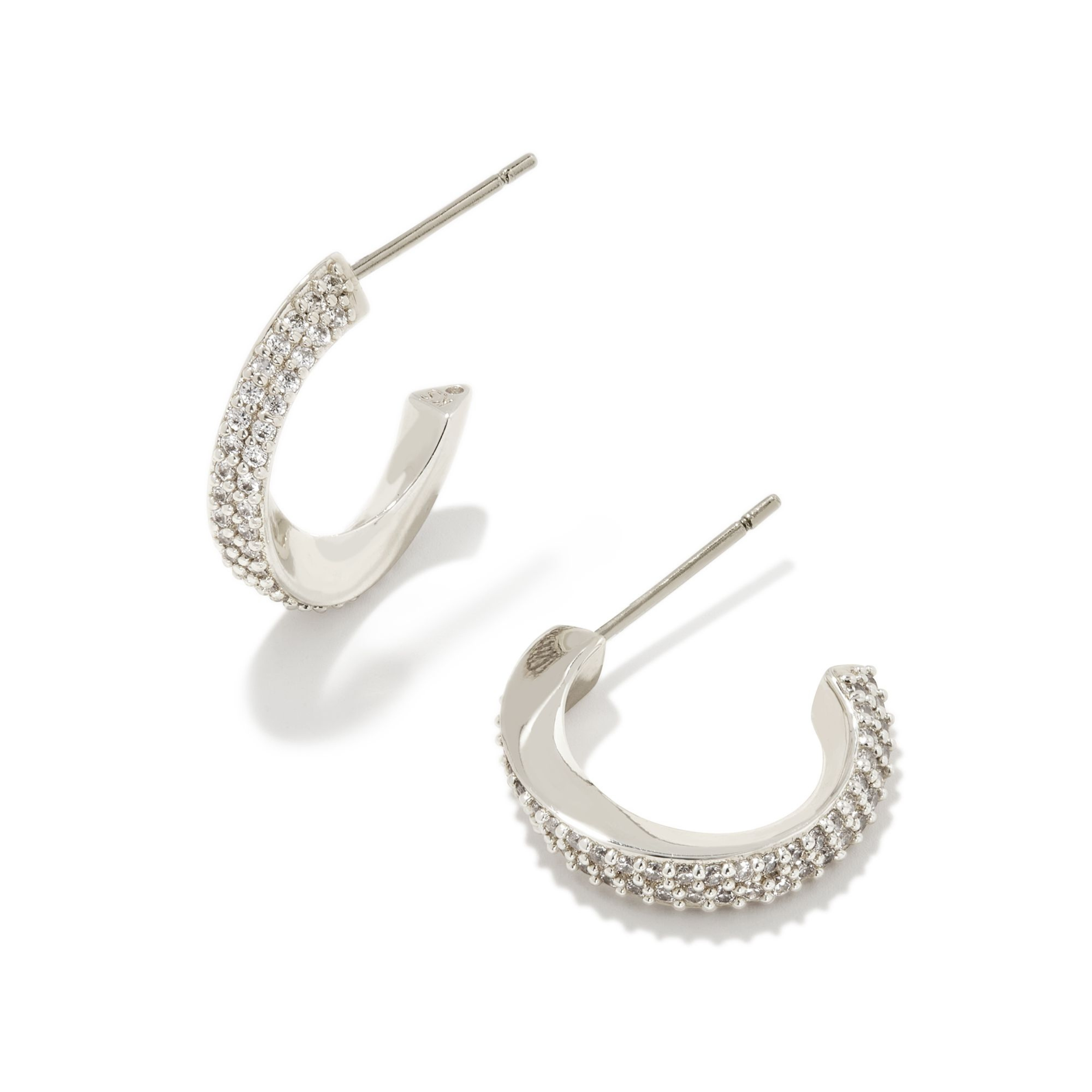 Silver hoop huggie twist earrings with cz crystals pictured on a white background. 