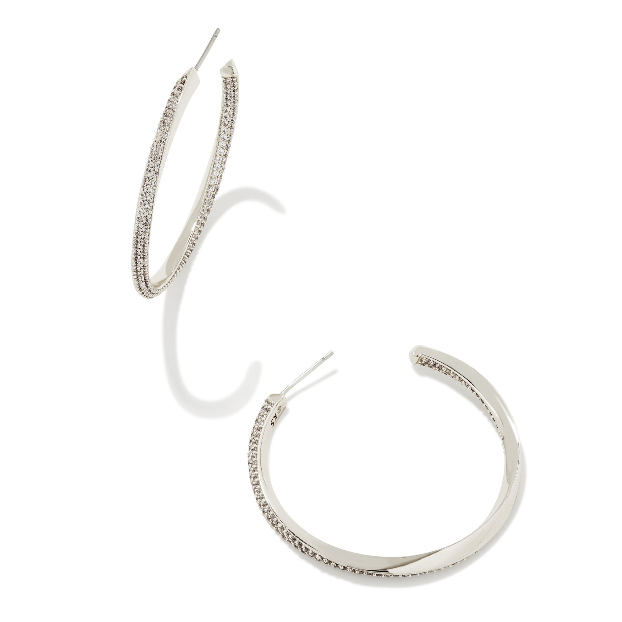 Silver hoop huggie twist earrings with cz crystals pictured on a white background. 