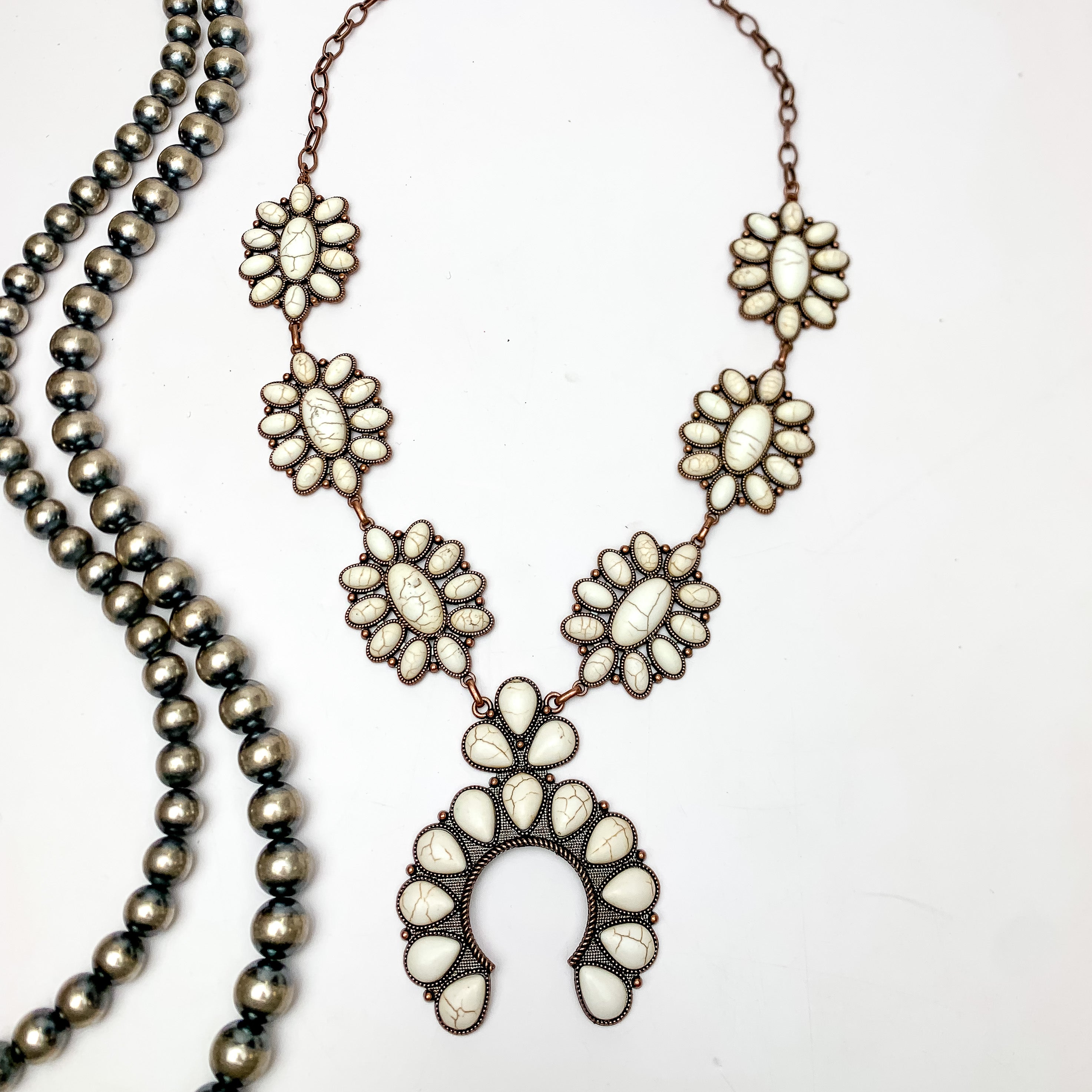 Squash Necklace with Oval Flowers in Copper Tone and White. This necklace is pictured on a white background with Navajo pearls on the left side.