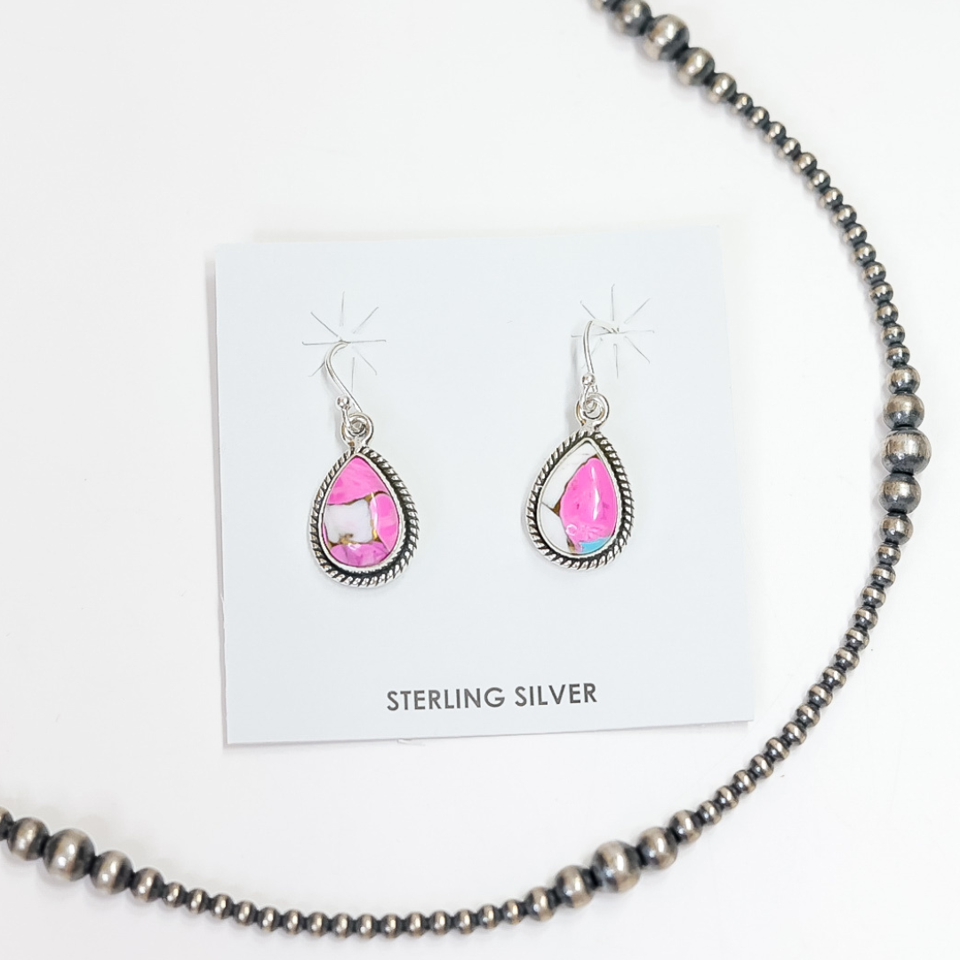 Sterling silver teardrop earrings with bright pink cotton candy turquoise stones on white display card.
