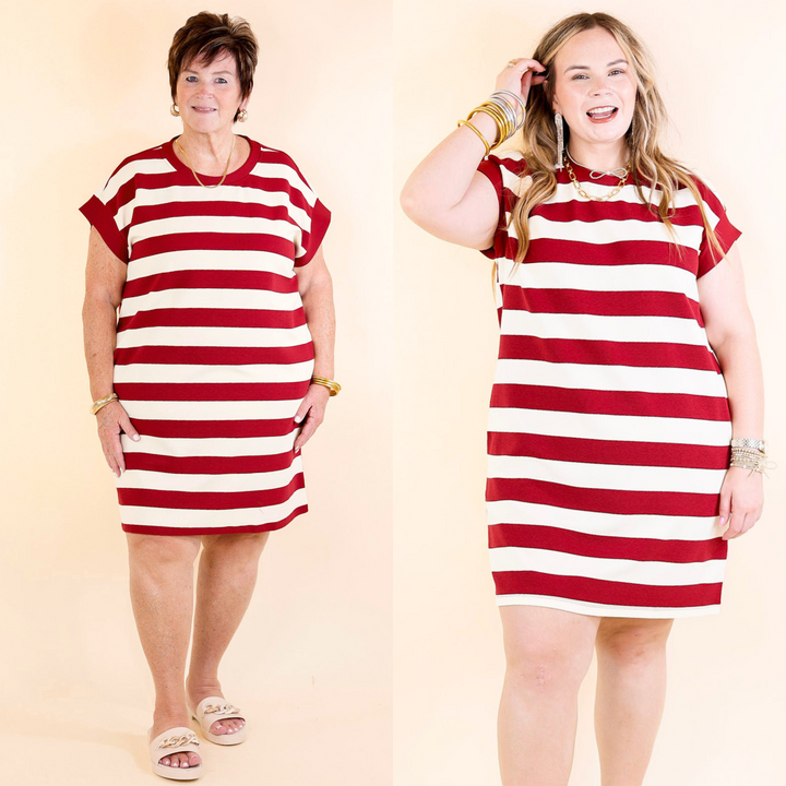 Models wearing a striped dress in burgundy and cream with cap sleeves. 