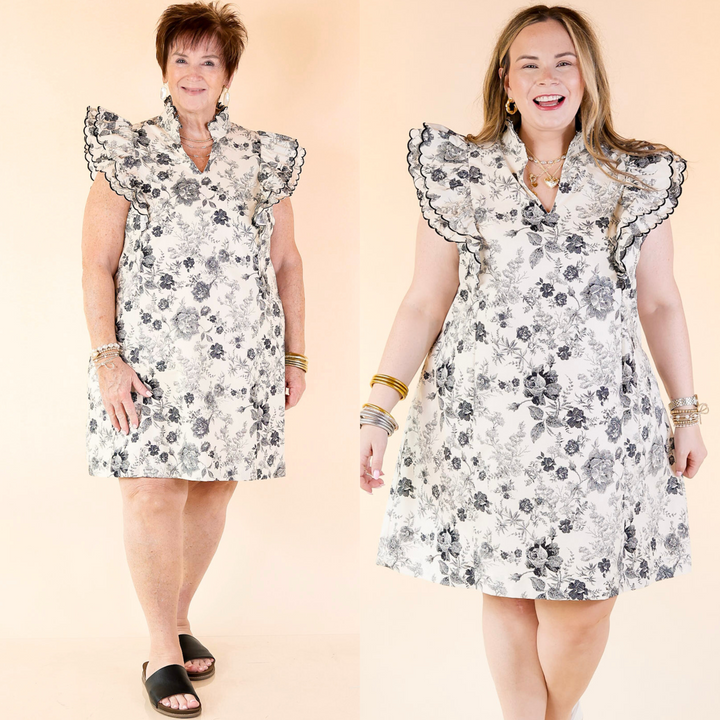 short cream colored dress with a black floral print that features a v neck with a collar, and ruffle cap sleeves. Featuring a plus size model, this dress is currently only available in plus sizes.