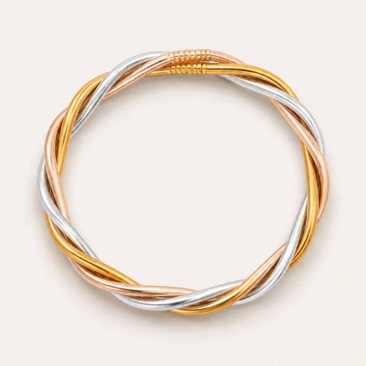Tri-color braided bracelet on a light beige background