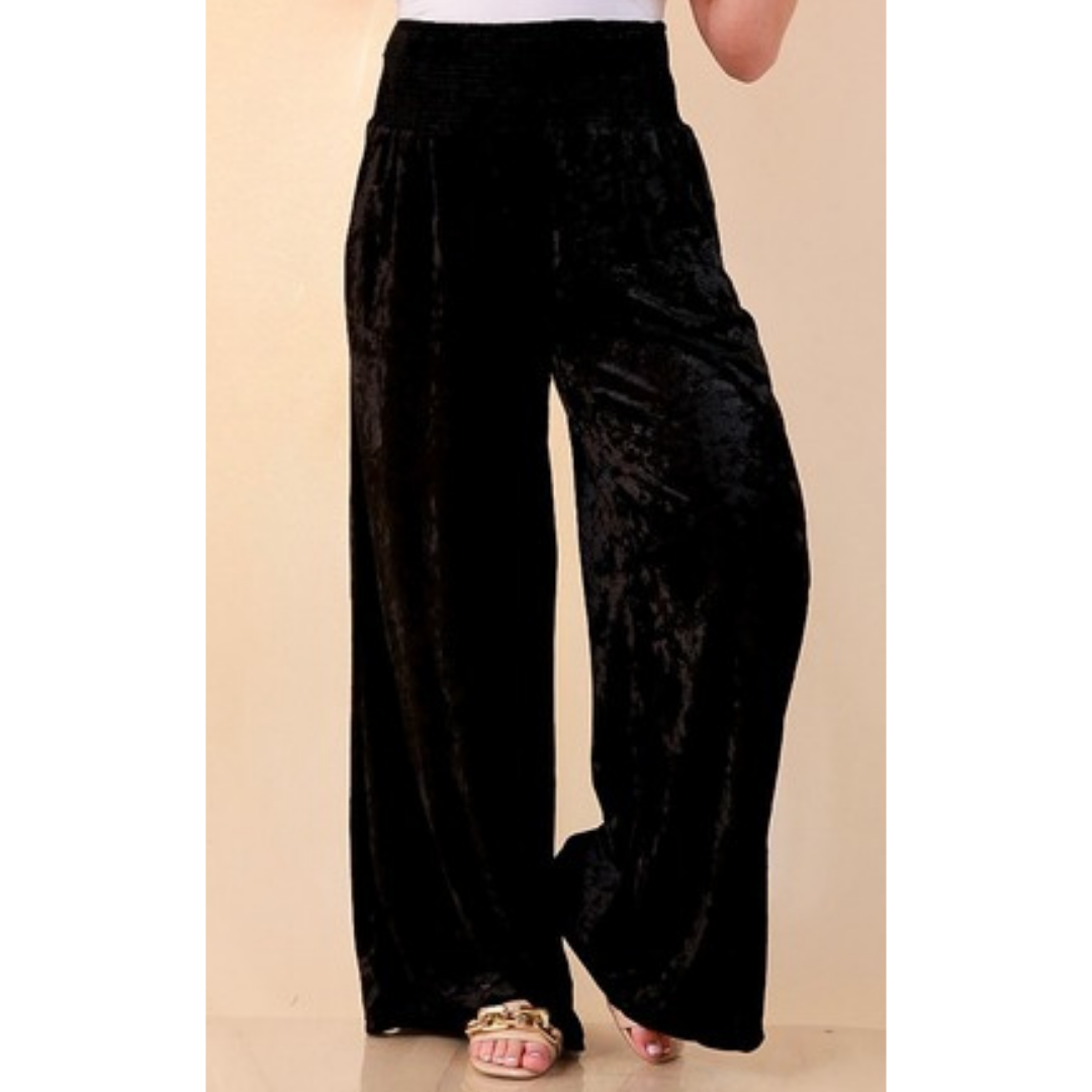 Full length image of a woman wearing the Velvet Hour Smocked Waist Crushed Velvet Wide Leg Pants in Black