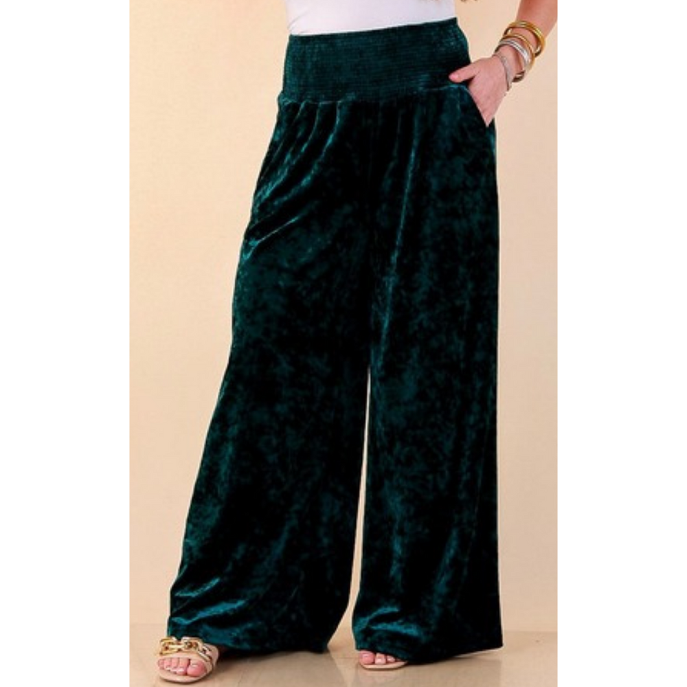 Full length image of a woman wearing the Velvet Hour Smocked Waist Crushed Velvet Wide Leg Pants in Teal
