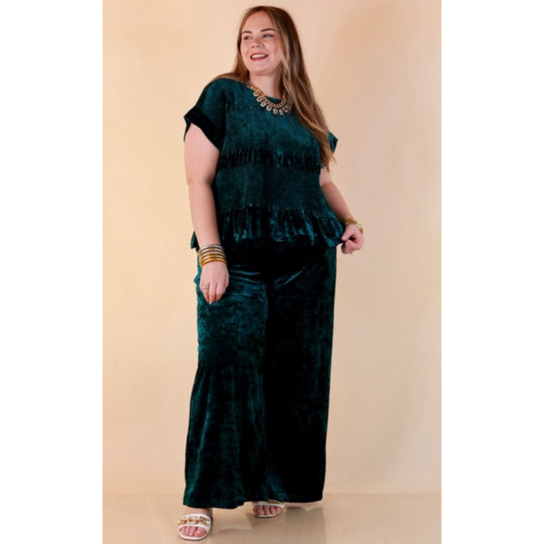 Full length image of a woman wearing the Velvet Hour Smocked Crushed Velvet Cap Sleeve Peplum Top in Teal