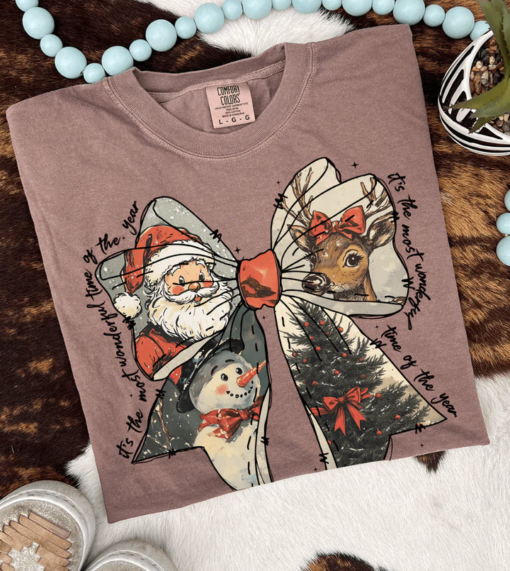 Folded brown sweatshirt with Christmas-themed graphics on a textured surface.