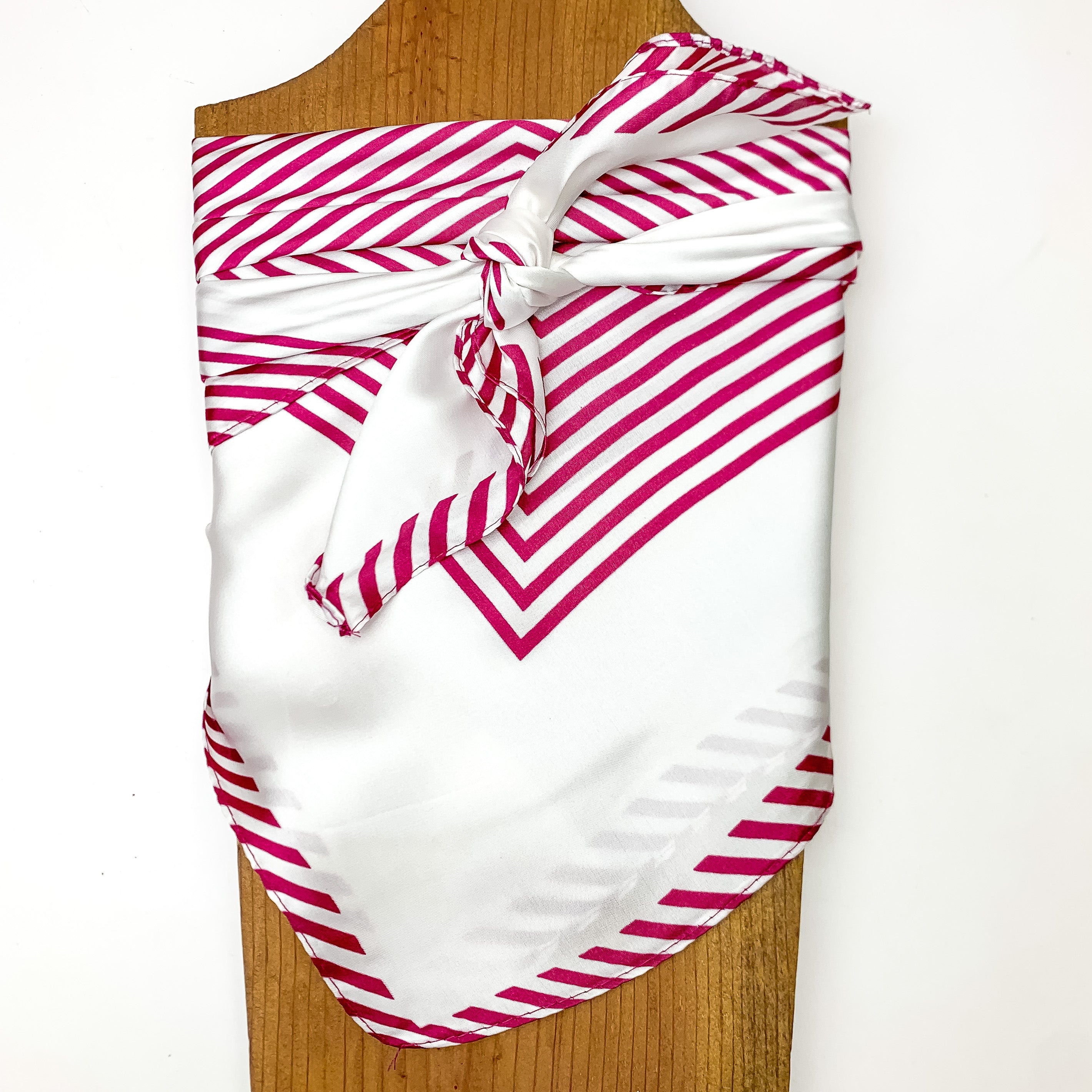Stripped Wild Rag in White and Maroon. Pictured tied around a wood piece with a white background.