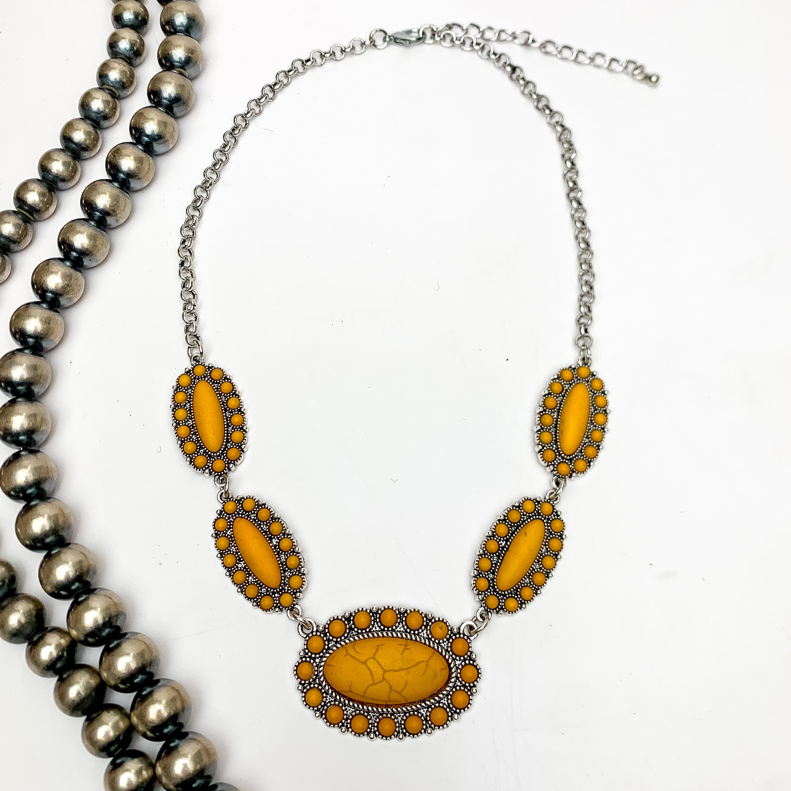 Western Silver Tone Necklace in Yellow. This necklace is on a white background with Navajo pearls on the left.