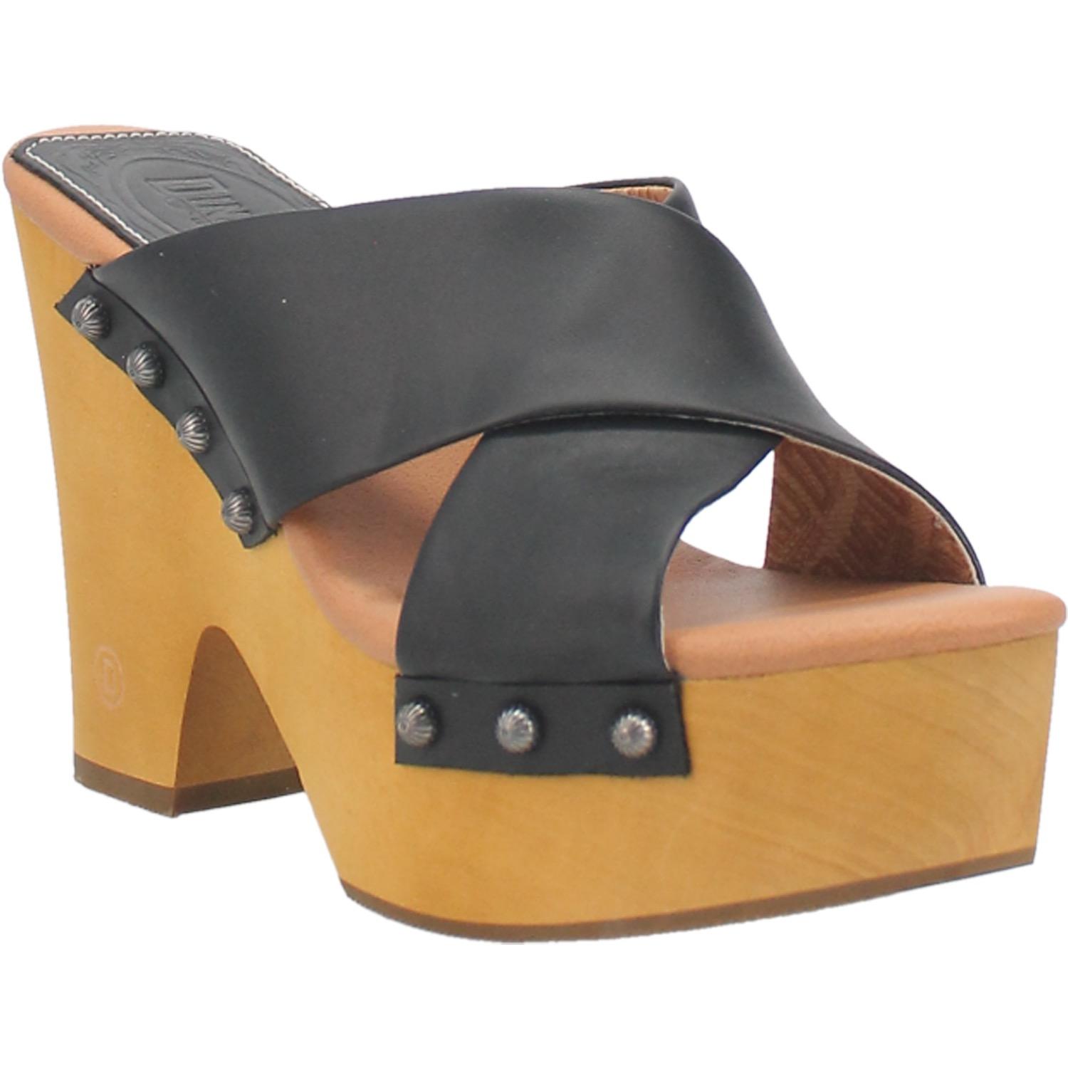 A chunky heeled sandal with two black crossed straps that are fastened in place with round studs. Item is pictured on a plain white background