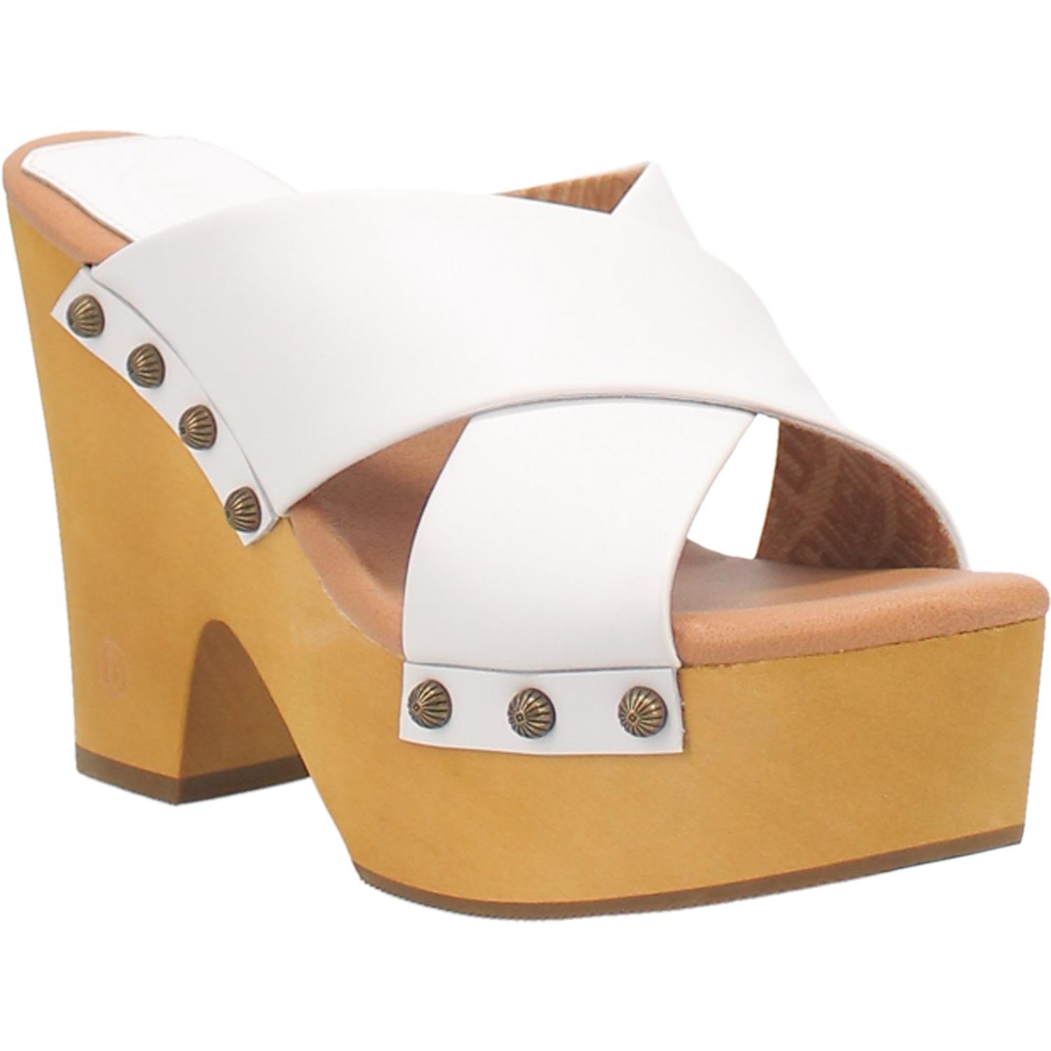 A chunky heeled sandal with two white crossed straps that are fastened in place with round studs. Item is pictured on a plain white background