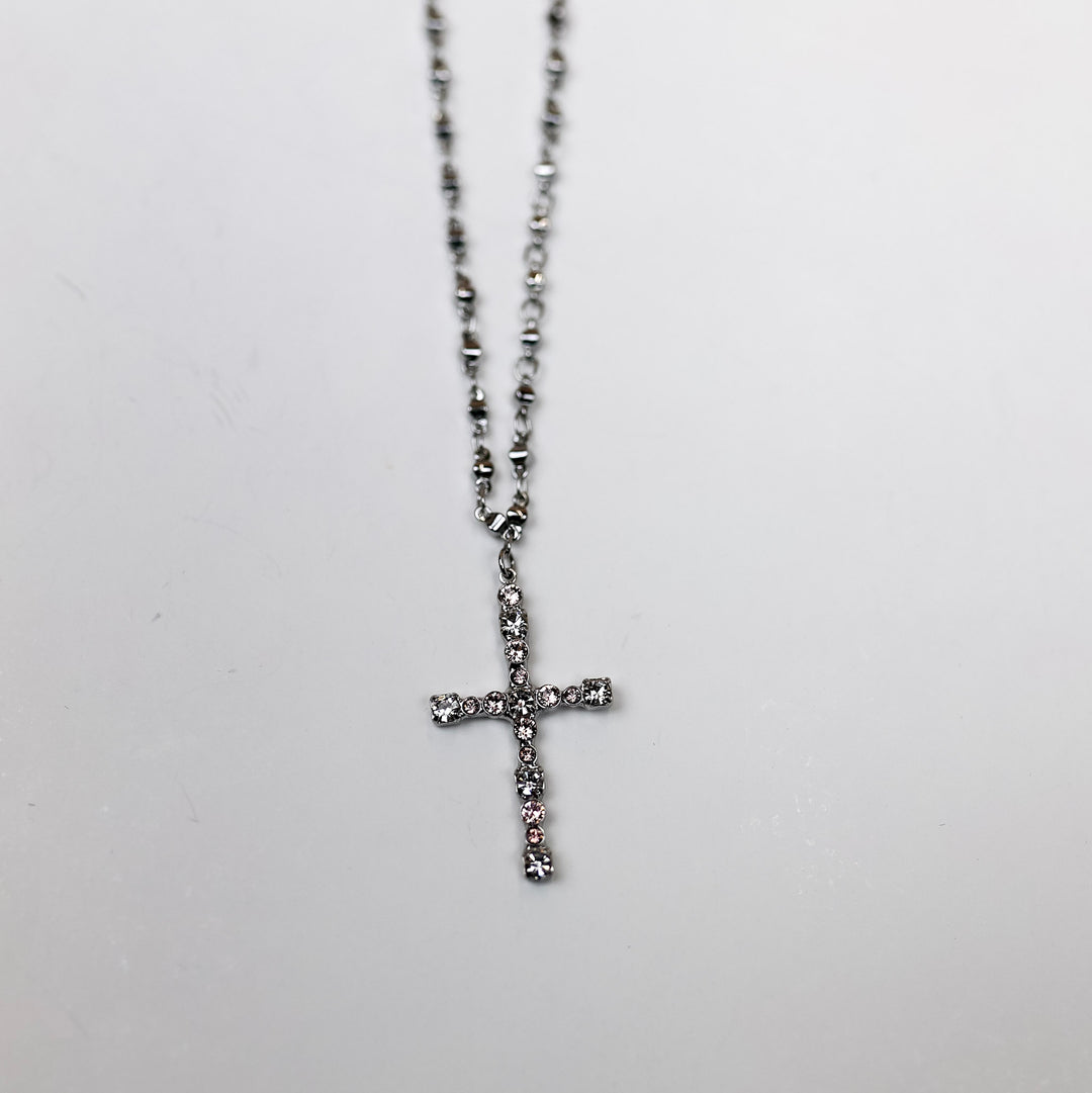 A silver-tone necklace with a Cross pendant that has crystals on it.