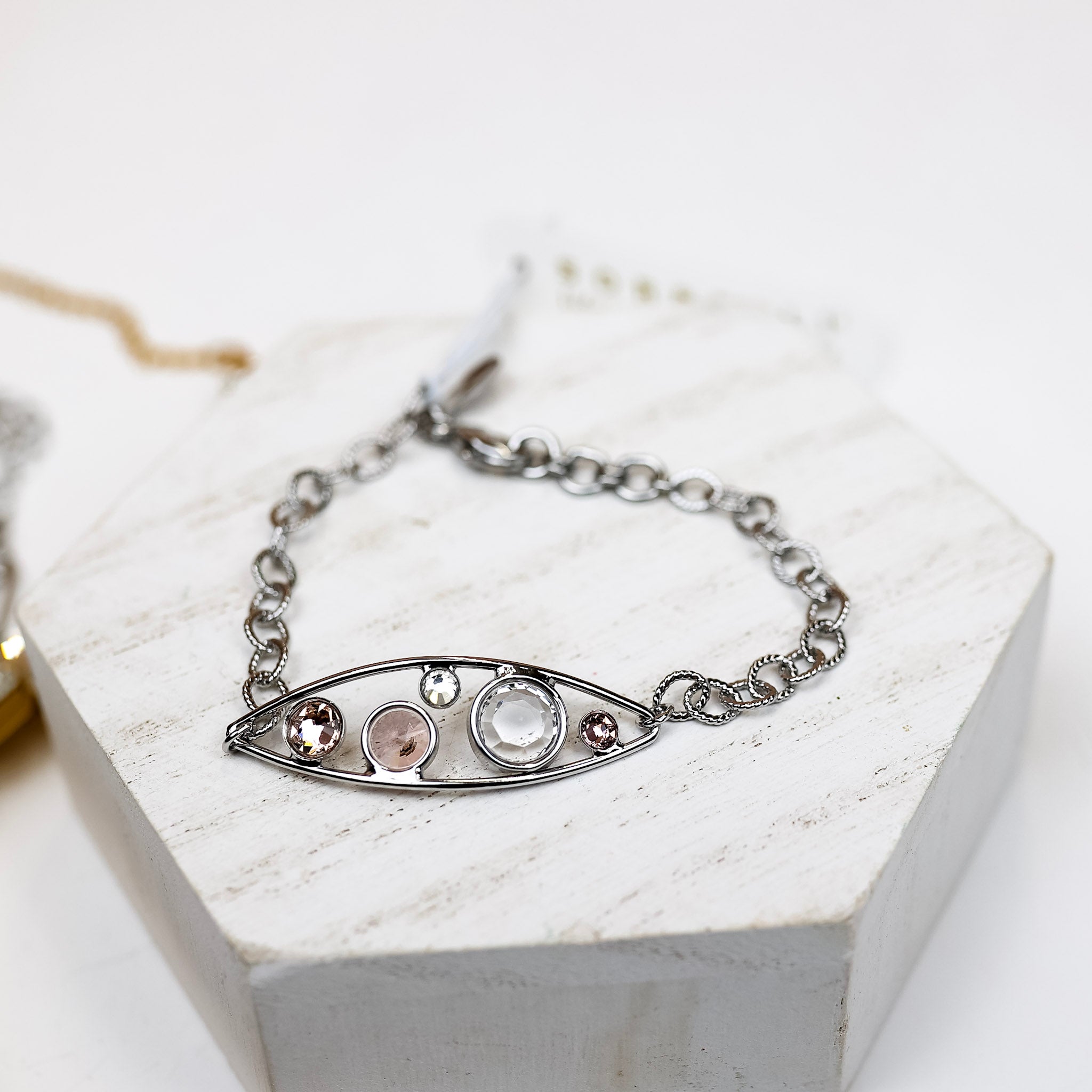A silver-tone tennis bracelet with an oval outline pendant with crystals inside.