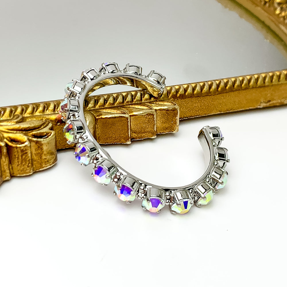 Silver cuff bracelt with silver crystals most of the way around. Pictured with a white background and a mirror with a gold trim
