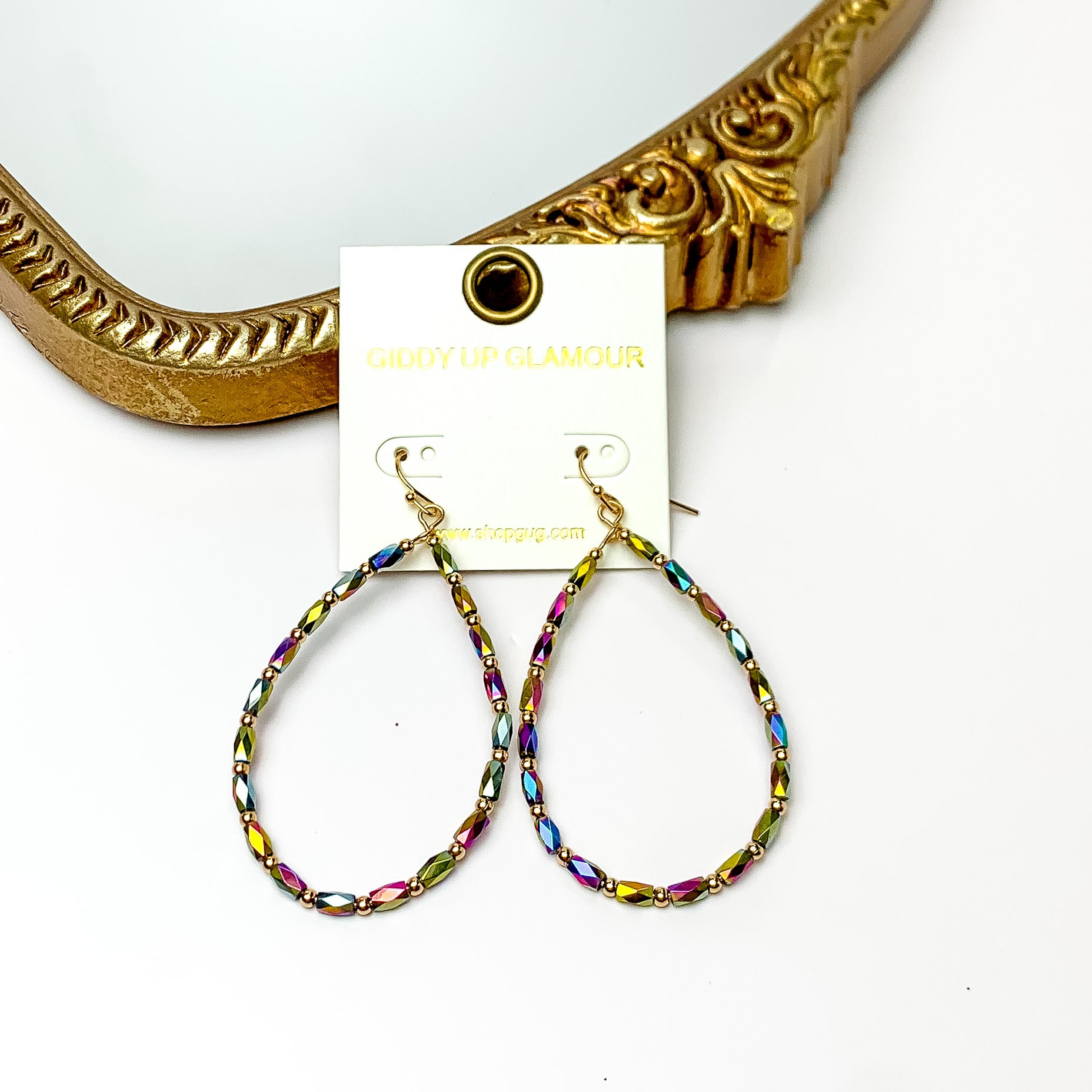 Multicolored open drop earrings with gold tone accents. Pictured on a white background with a gold frame through it.