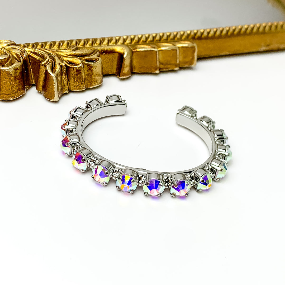 Silver cuff bracelt with silver crystals most of the way around. Pictured with a white background and a mirror with a gold trim