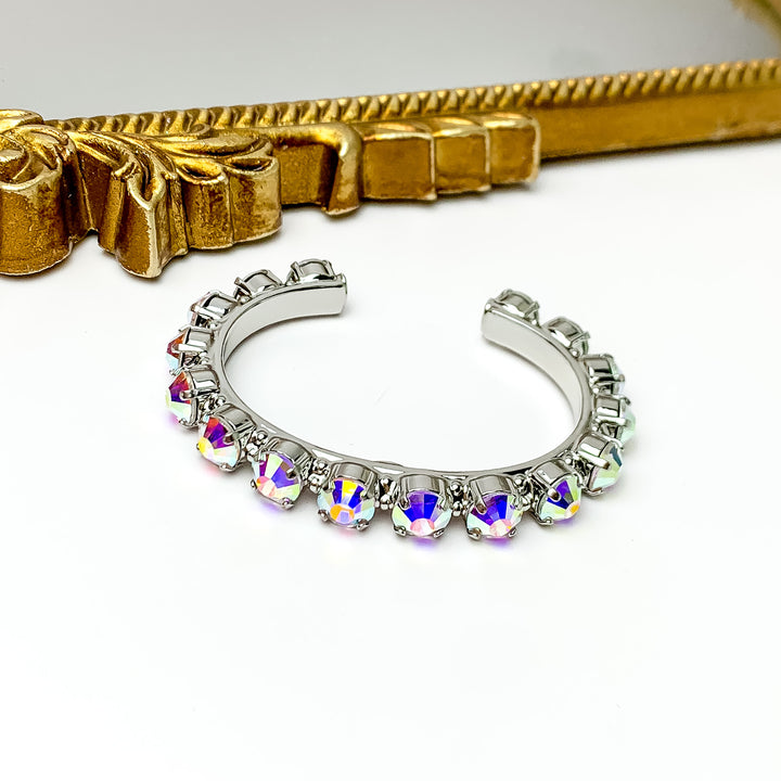Silver cuff bracelt with silver crystals most of the way around. Pictured with a white background and a mirror with a gold trim