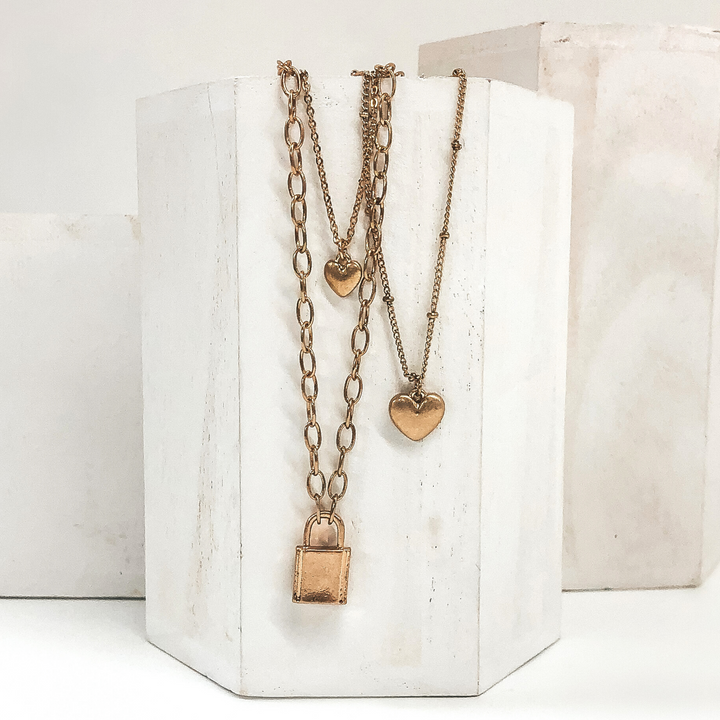 multiple gold chained necklace with 2 heart charms and lock pendant