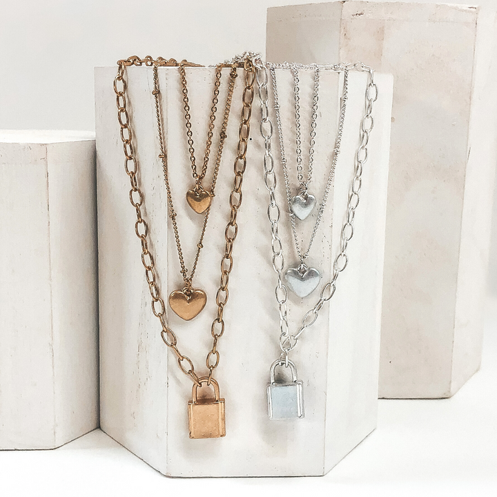 gold and silver multiple chained necklace with 2 heart charms and lock pendant