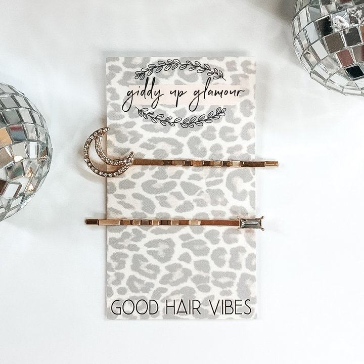 gold hair pins; one with a moon and one with a baguette
