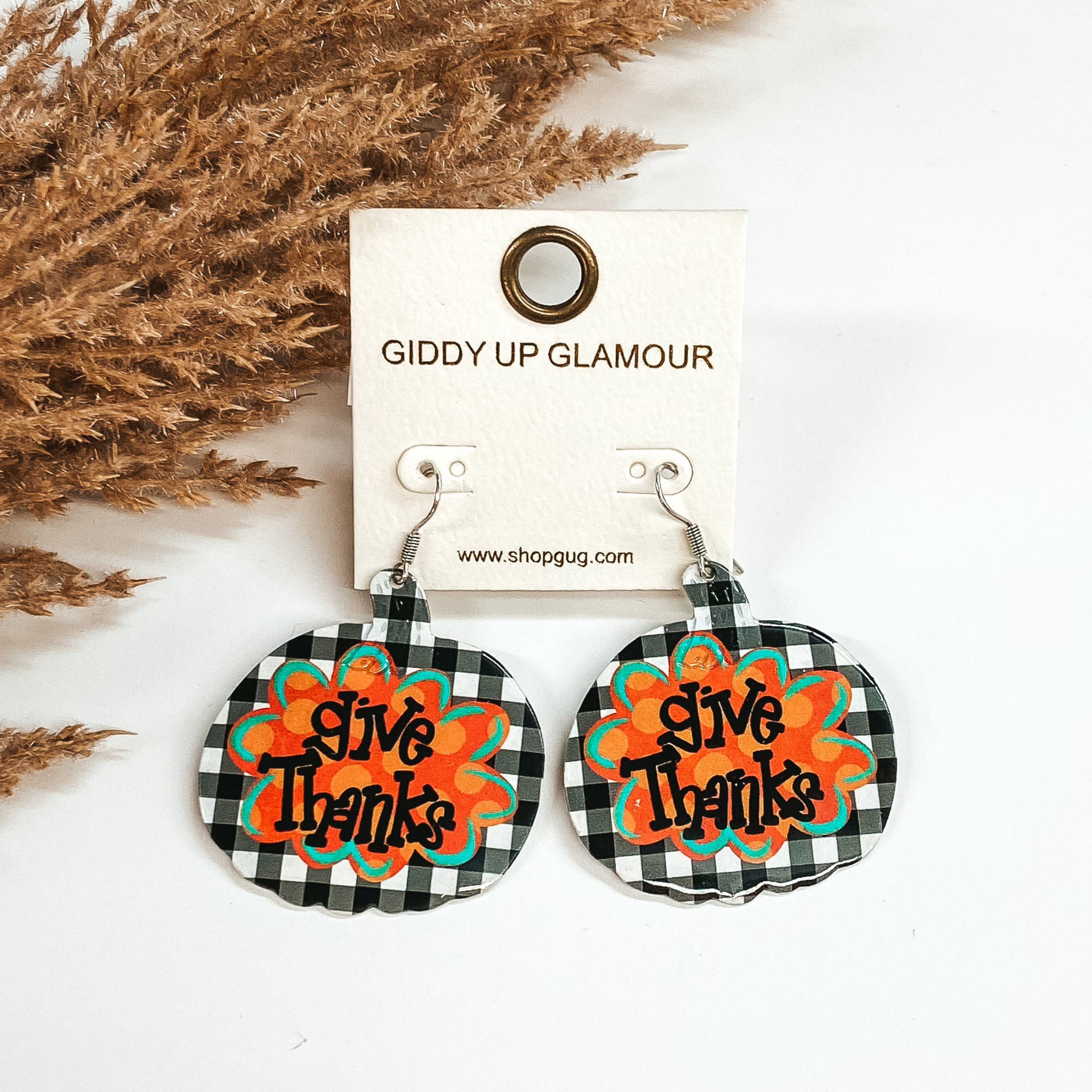 white buffalo plaid pumpkin earrings with give thanks written in the middle