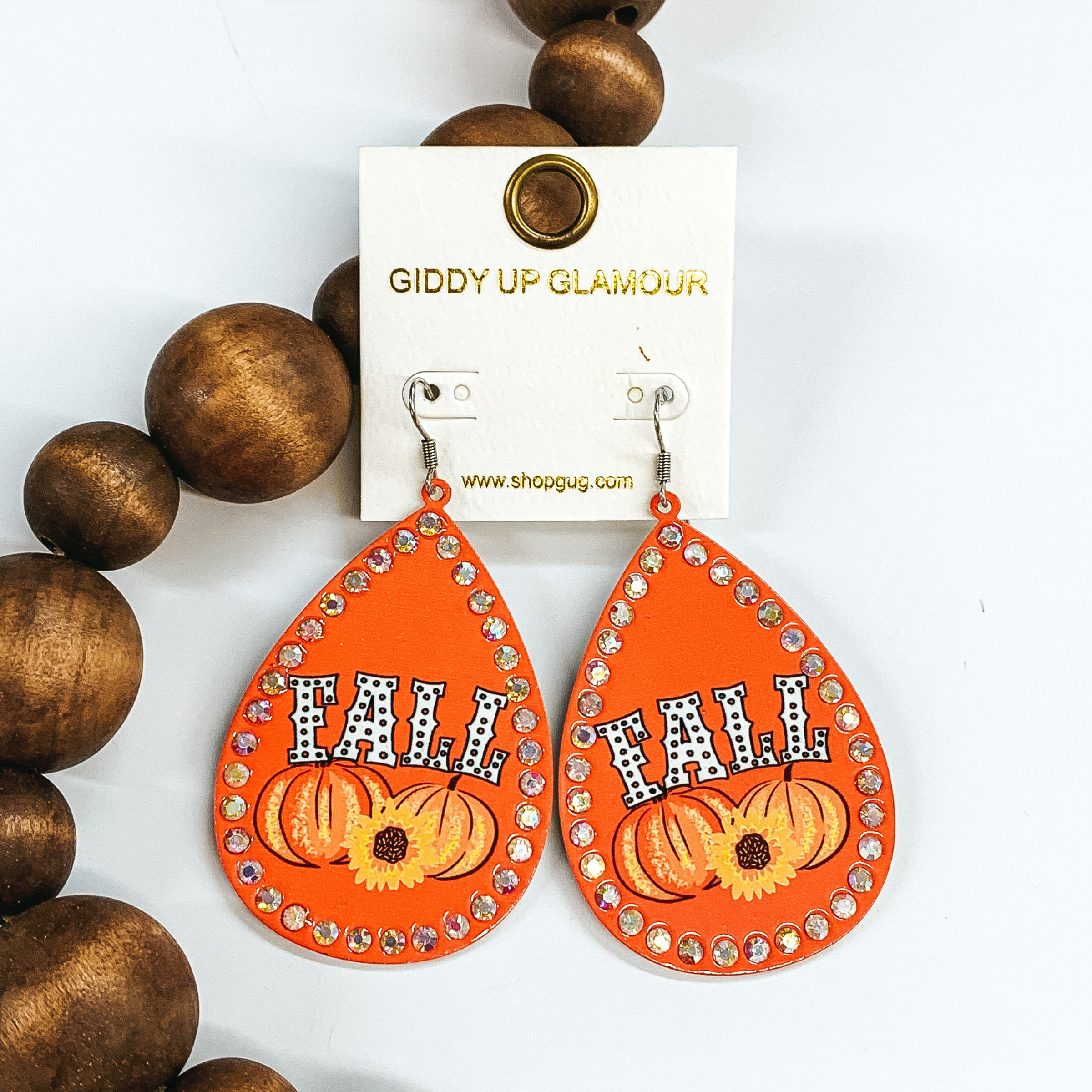 orange earrings with pumpkins and sunflowers with the word fall written in the middle
