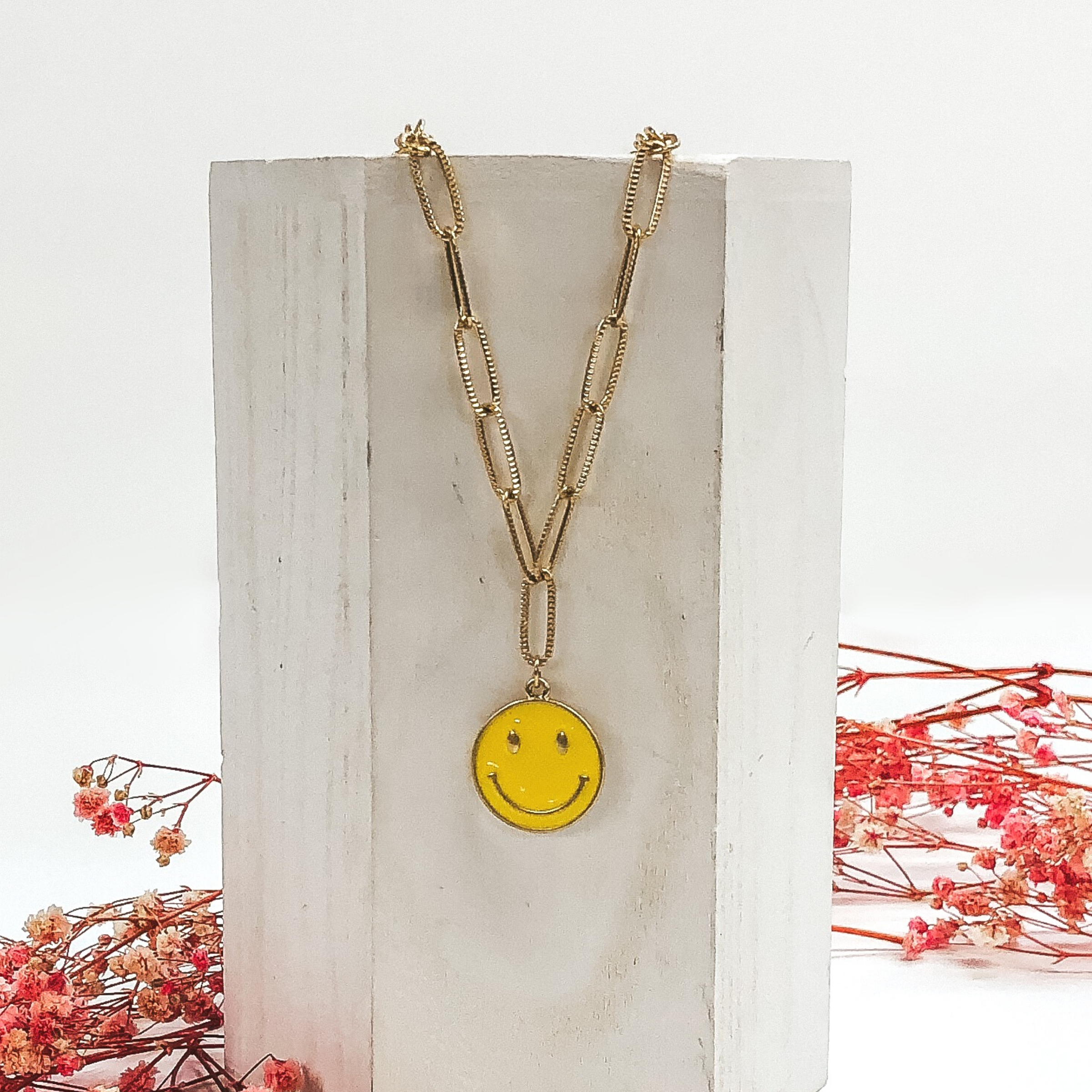 gold necklace with yellow smiley face