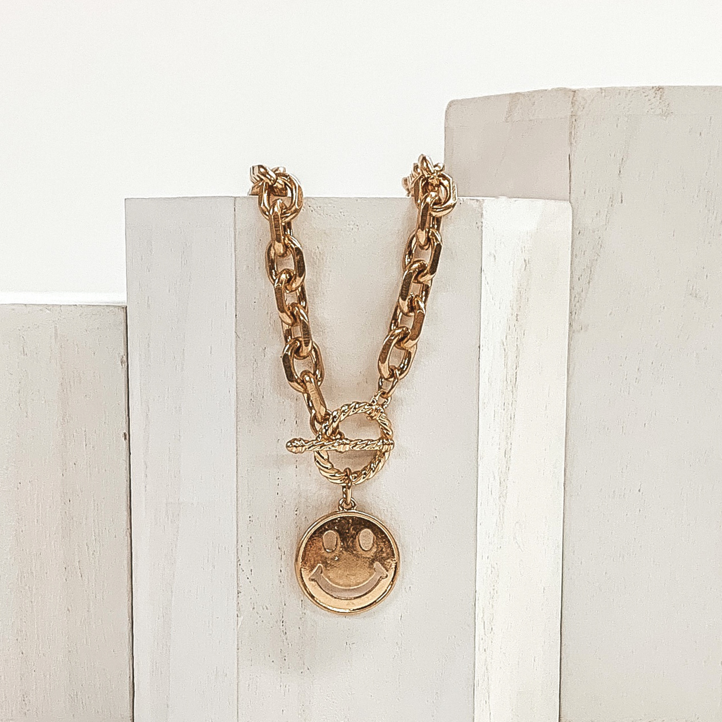 chained gold necklace with smiley face pendant and toggle clasp 