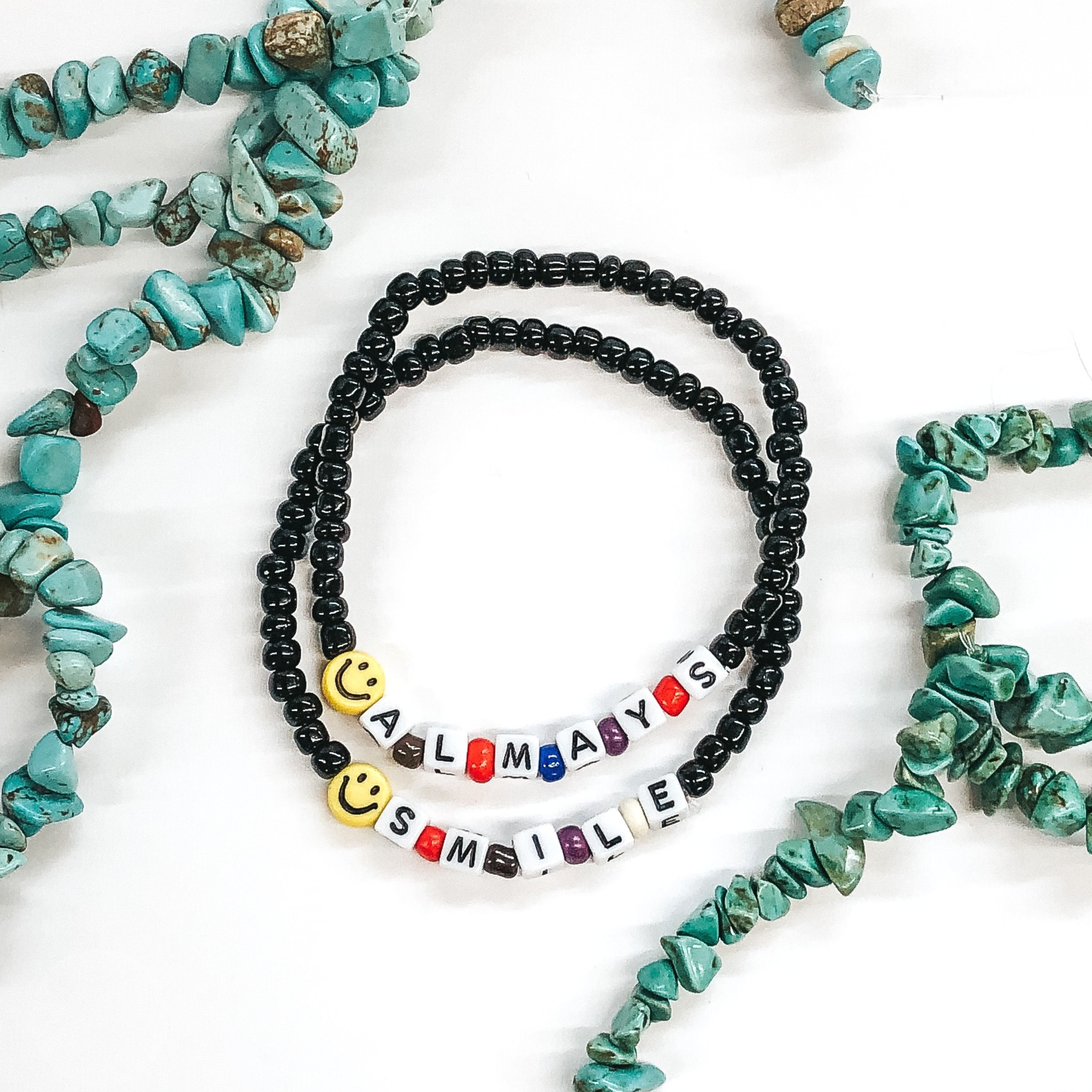 2 black beaded bracelets with smiley face beads and lettering that says always smile