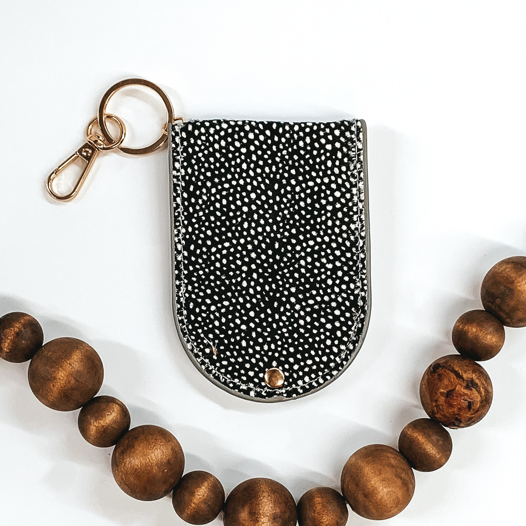 half circle snap closure hair on hide wallet that is black with white dots on a gold key ring and key clip picture on a white background 