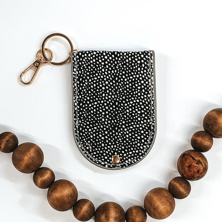 half circle snap closure hair on hide wallet that is black with white dots on a gold key ring and key clip picture on a white background 