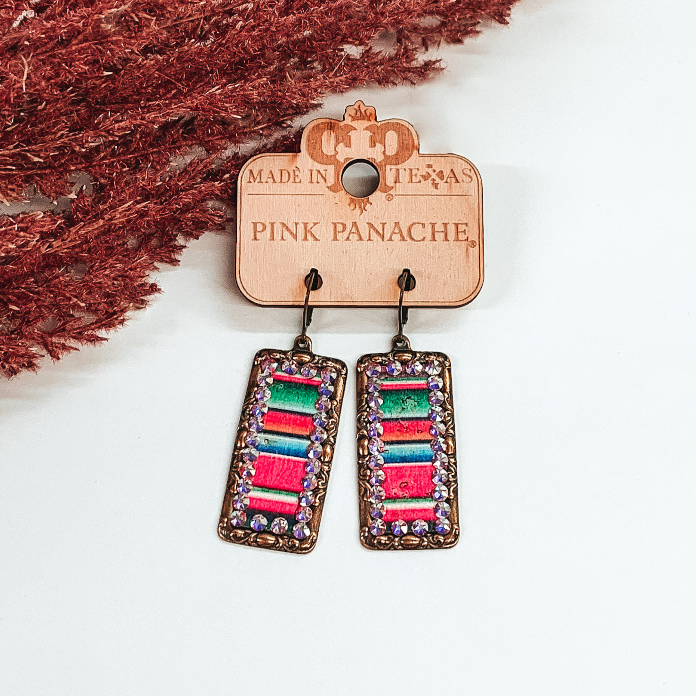 pink panache bronze rectangle earrings with colorful serape inlay with ab crystal outline on a white background
