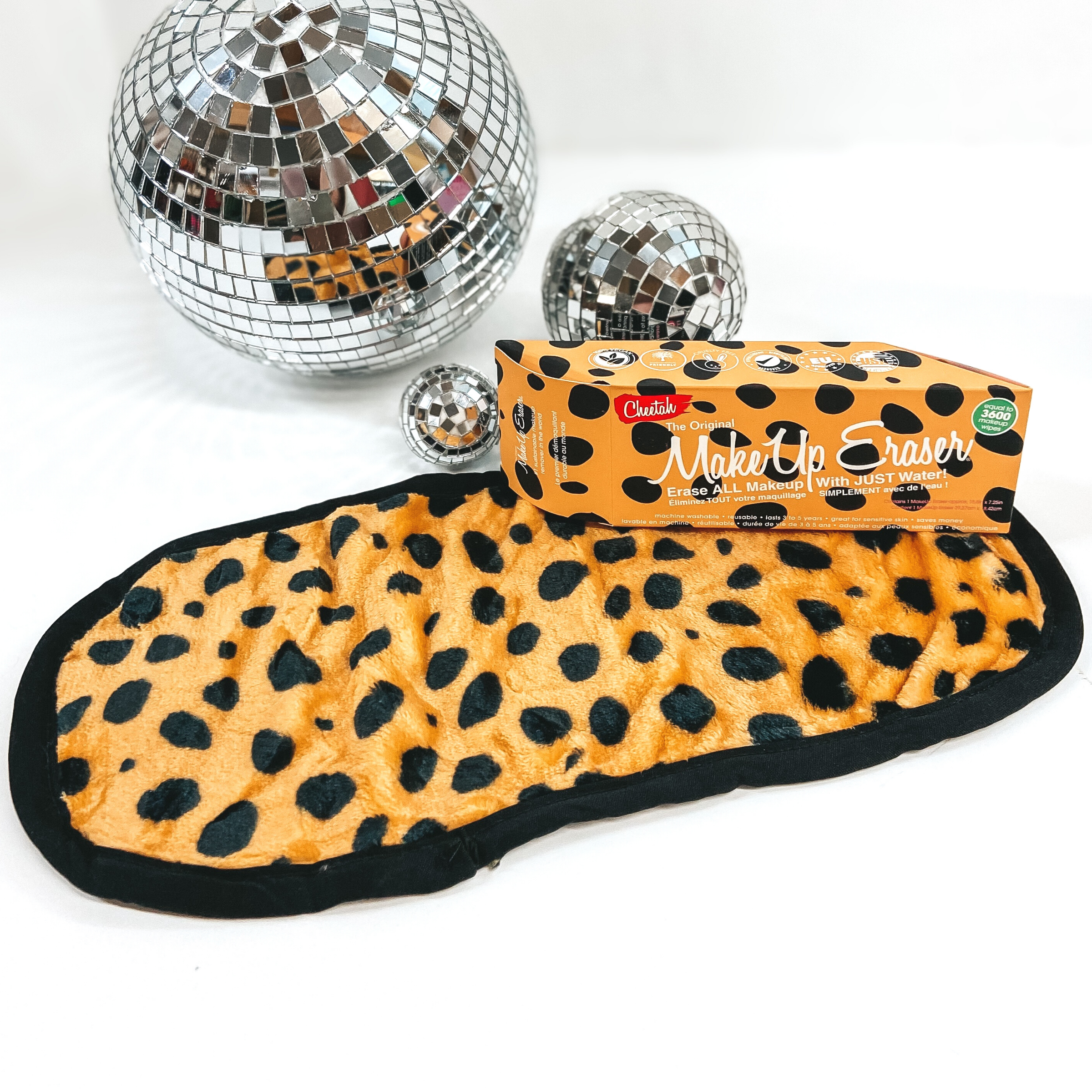 A cheetah print long, rounded rectangle cloth is pictured with a cheetah print box laying on one of the corners. This is pictured on a white background with a few disco balls in the top of the picture.