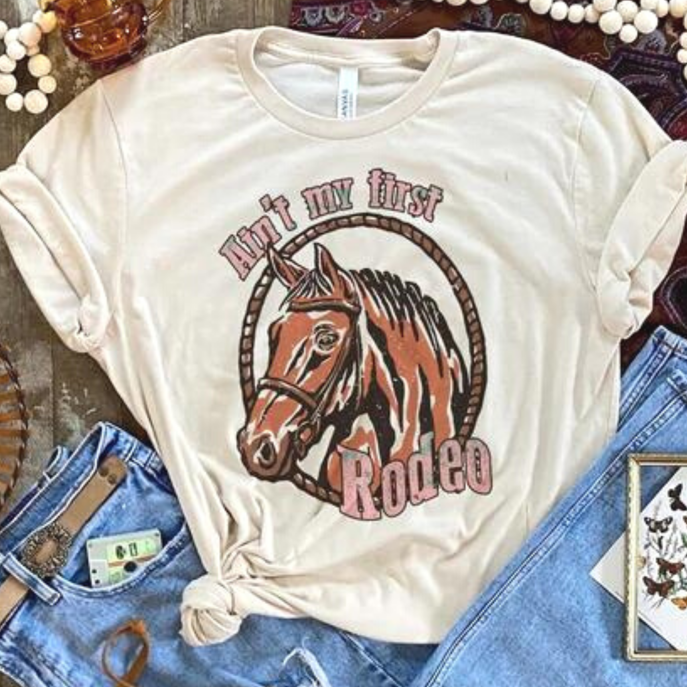 Online Exclusive | Ain't My First Rodeo Short Sleeve Graphic Tee in Cream - Giddy Up Glamour Boutique
