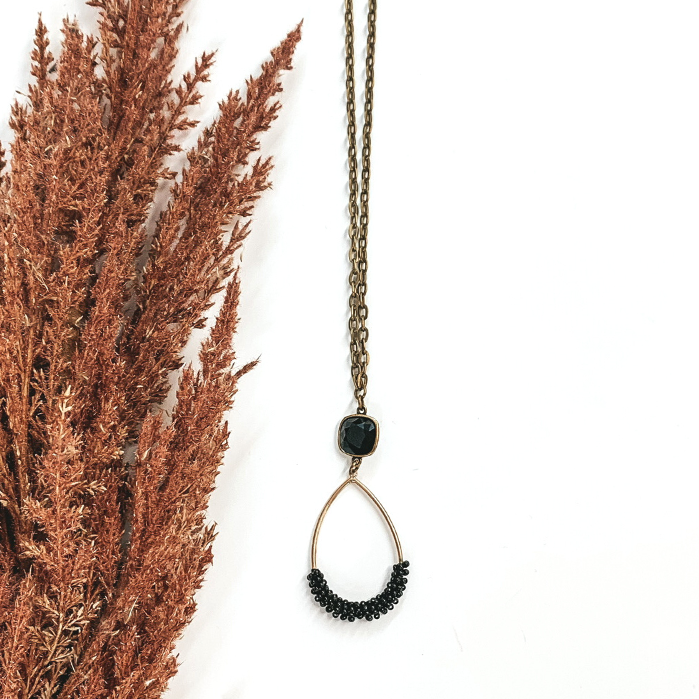 long gold chain necklace with black crystal pendant with hanging teardrop pendant with black beads
