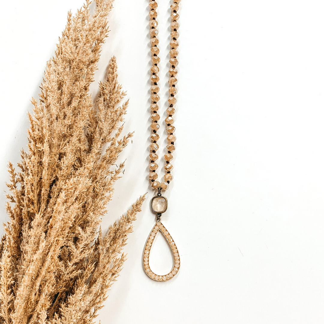 ivory/beige long beaded necklace with cream crystal charm and teardrop pendant