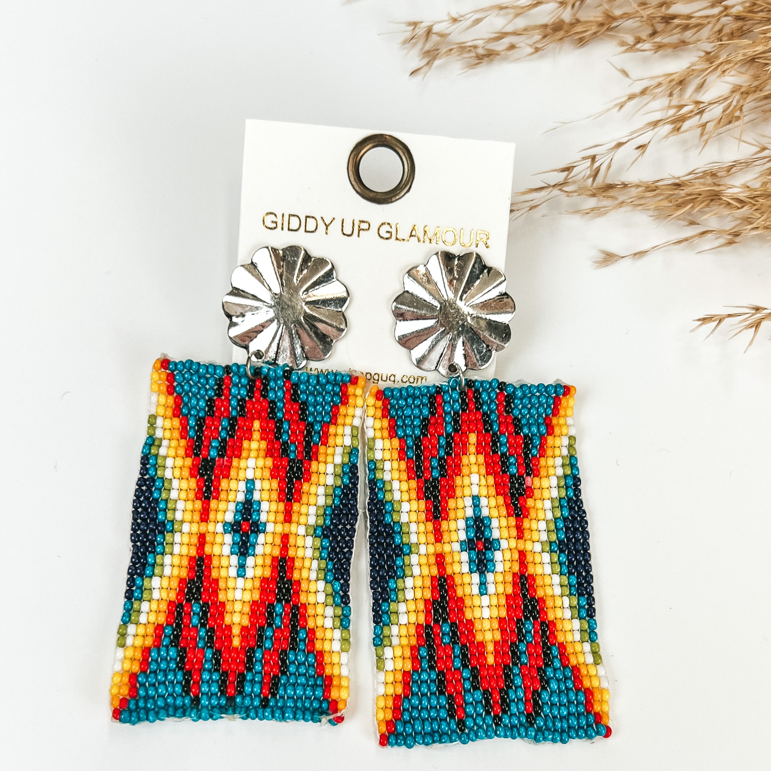 Silver Tone Concho Post Earrings with Rectangle Navajo Beaded Drop in White, with pompous grass in the top right hand corner, on a white background. 