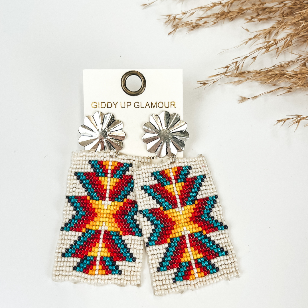 Silver Tone Concho Post Earrings with Rectangle Navajo Beaded Drop in White, with pompous grass in the top right hand corner, on a white background. 