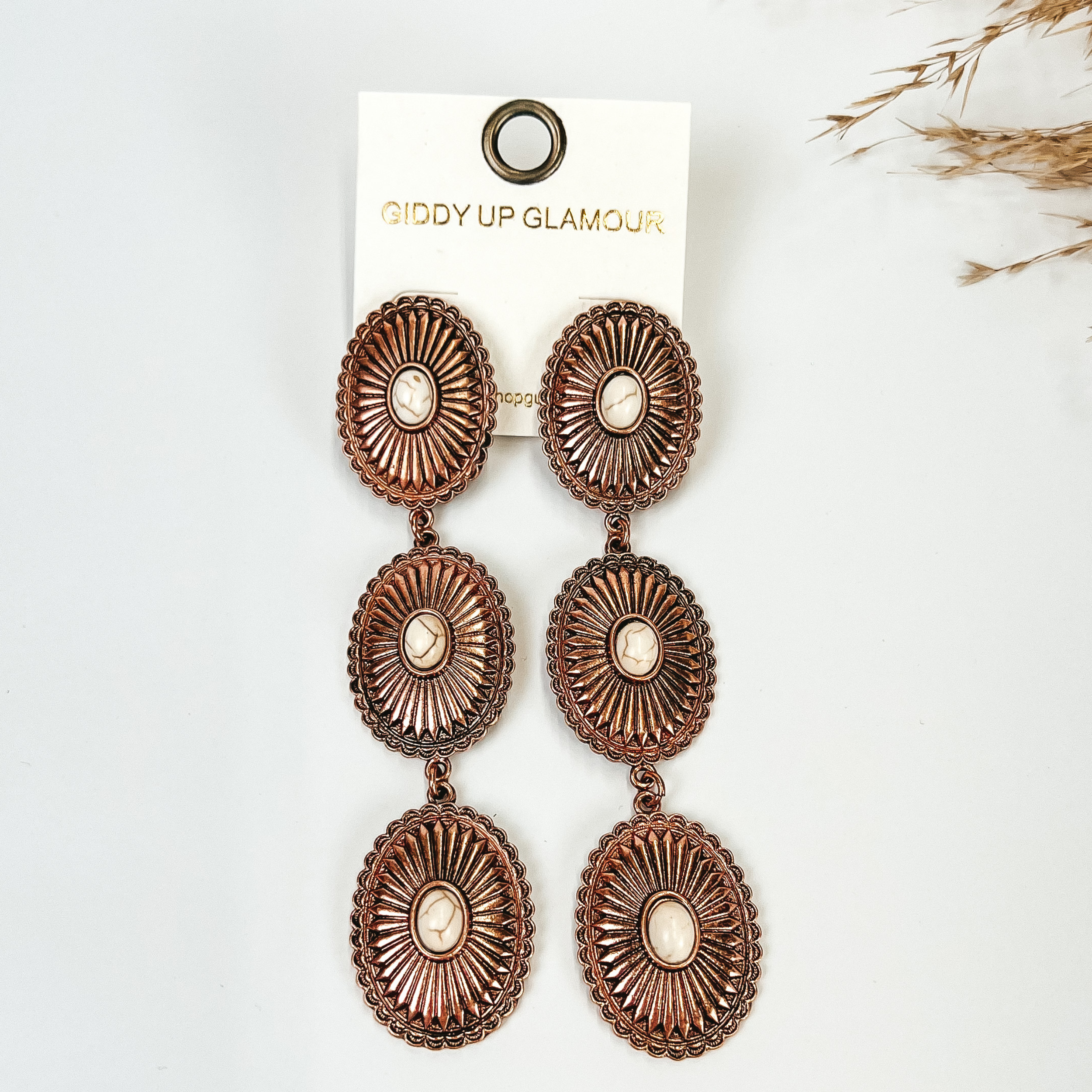 Concho Drop Earrings with White Stones in Copper Tone, with pompous grass in the top right hand corner, on a white background. 