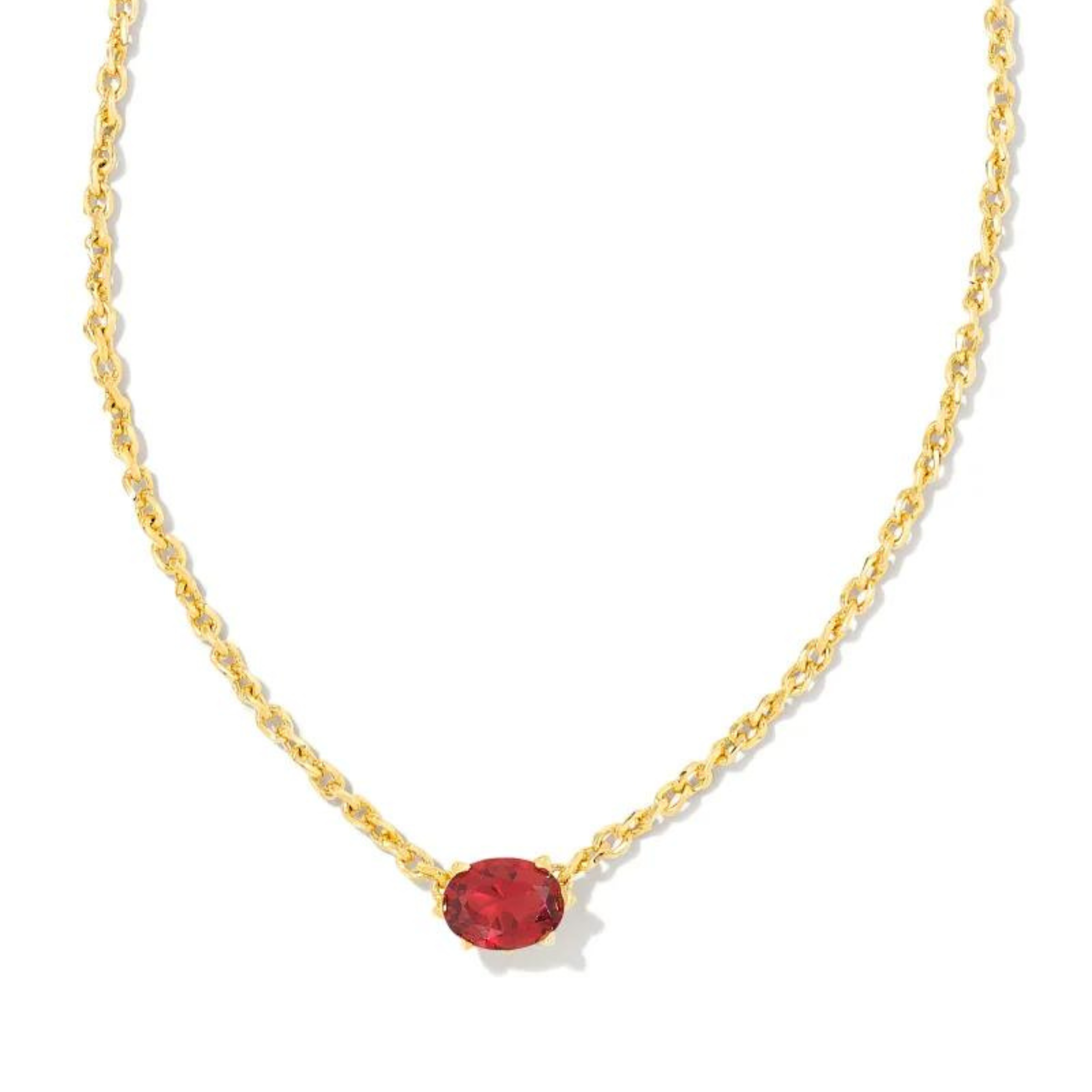 Gold chain necklace with a burgandy crystal pendatn, pictured on a white background.