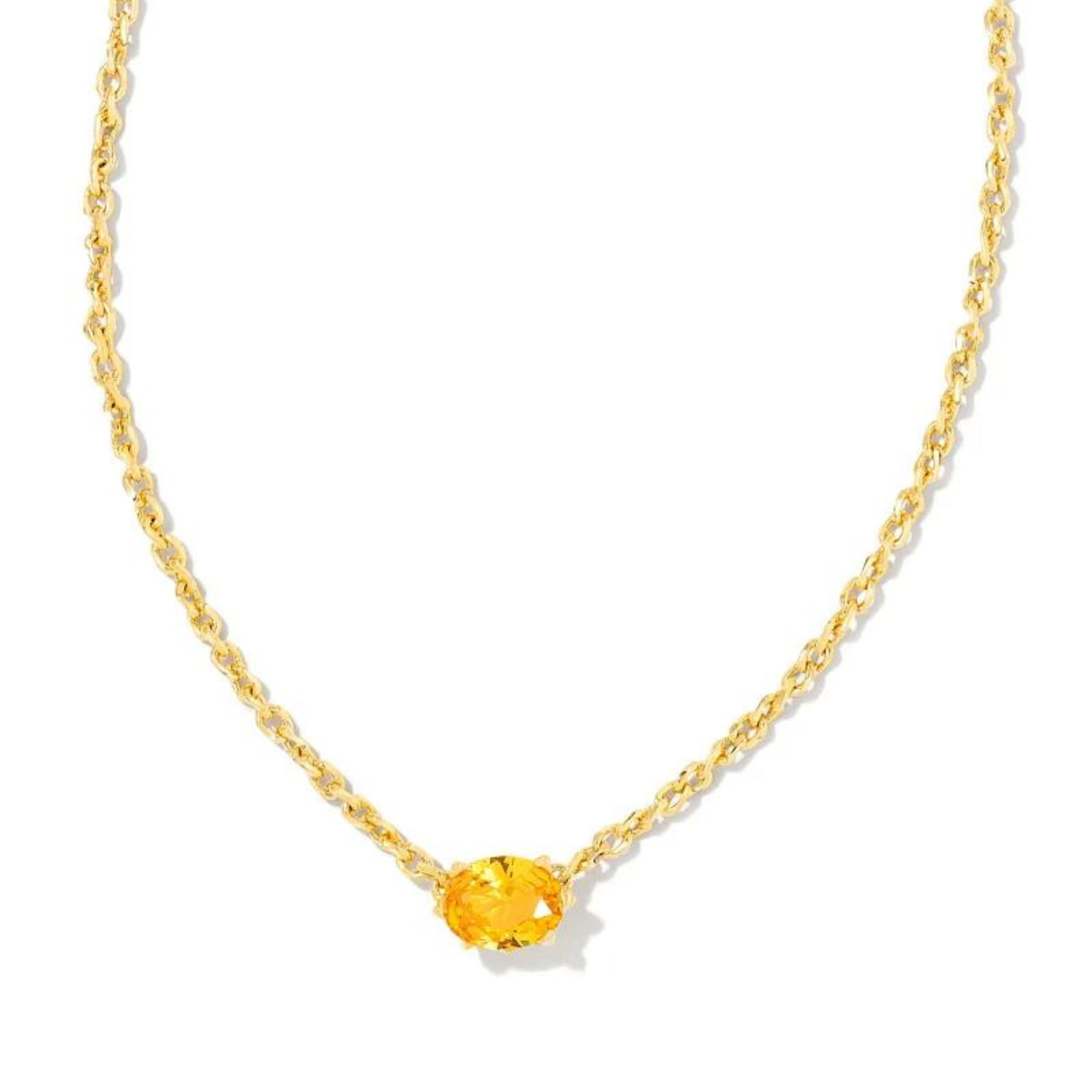 Gold necklace with golden yellow crystal pendant, pictured on a white background.