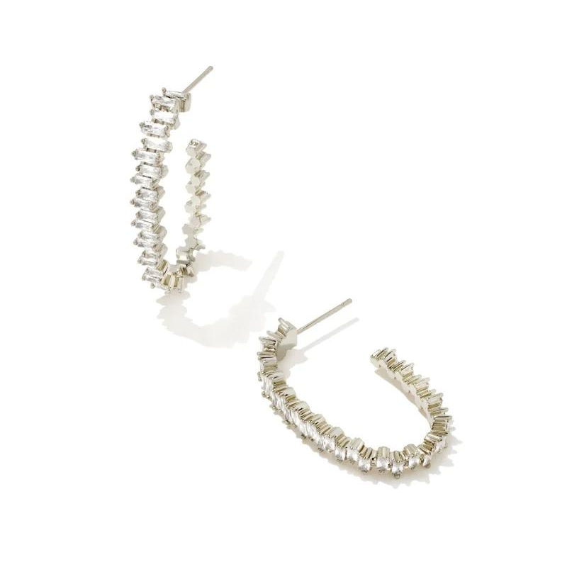 Silver oval hoop earrings with white crystals, pictured on a white background.