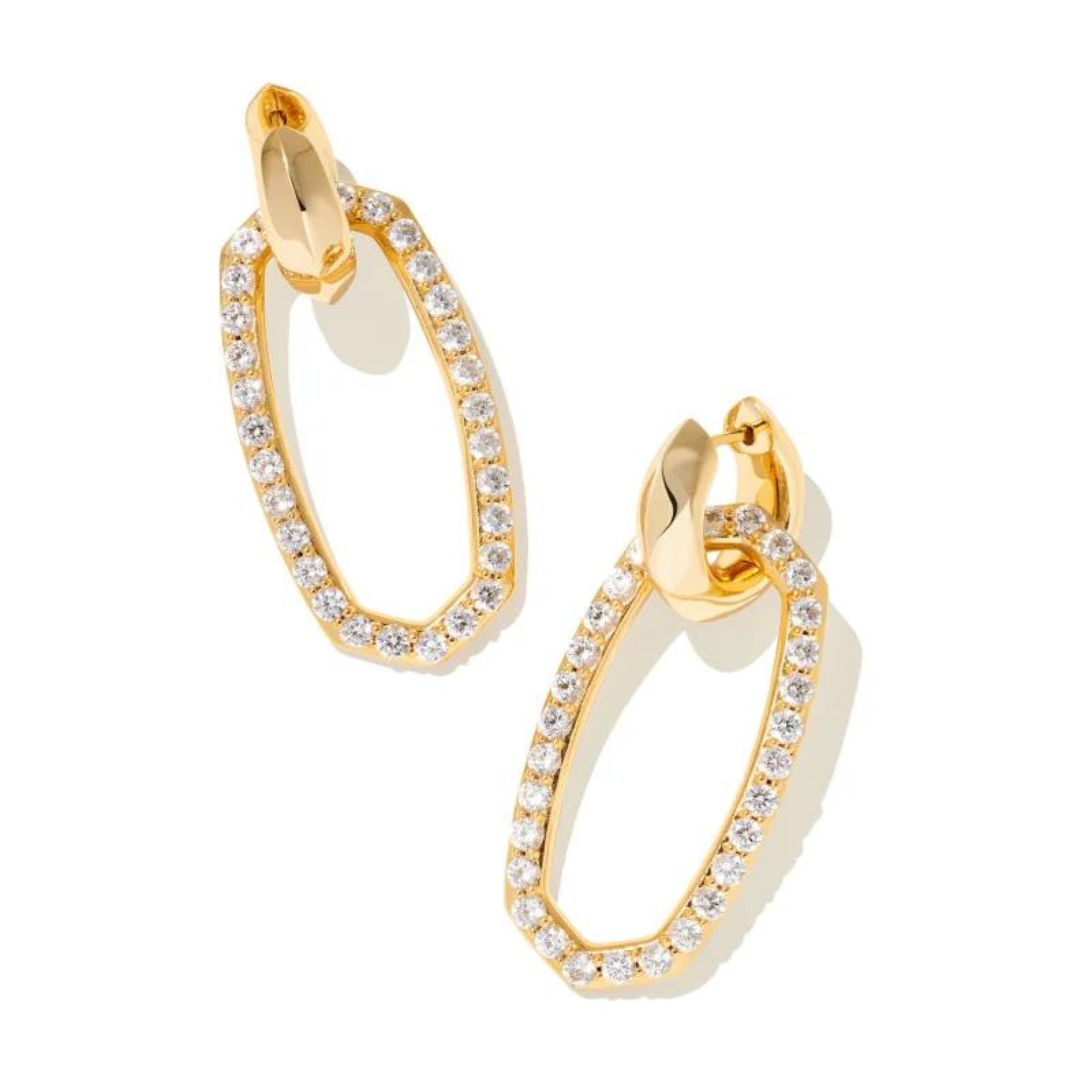 Gold hoop dangle earrings with white crystals pictured on a white background.