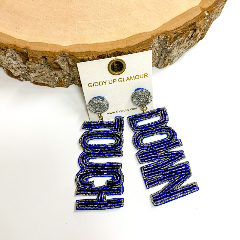 Navy circle post back earrings. These earrings include the words "Touch" and "Down" in navy beads. These earrings are pictured propped up on a circle piece of wood.