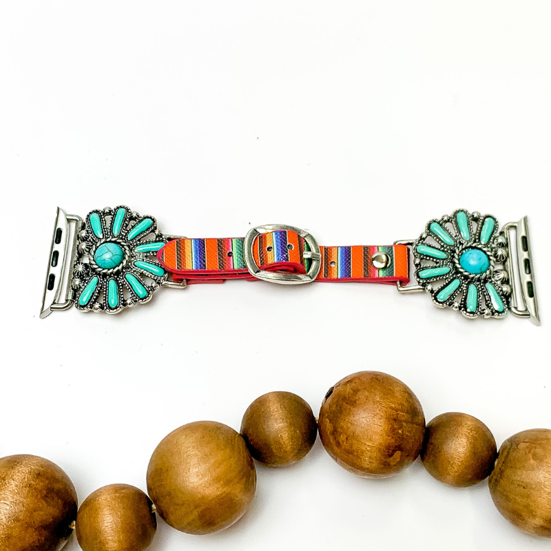 Pictured is a serape print watch band with half stone clusters in turquoise. They are pictured with wooden beads on a white background.