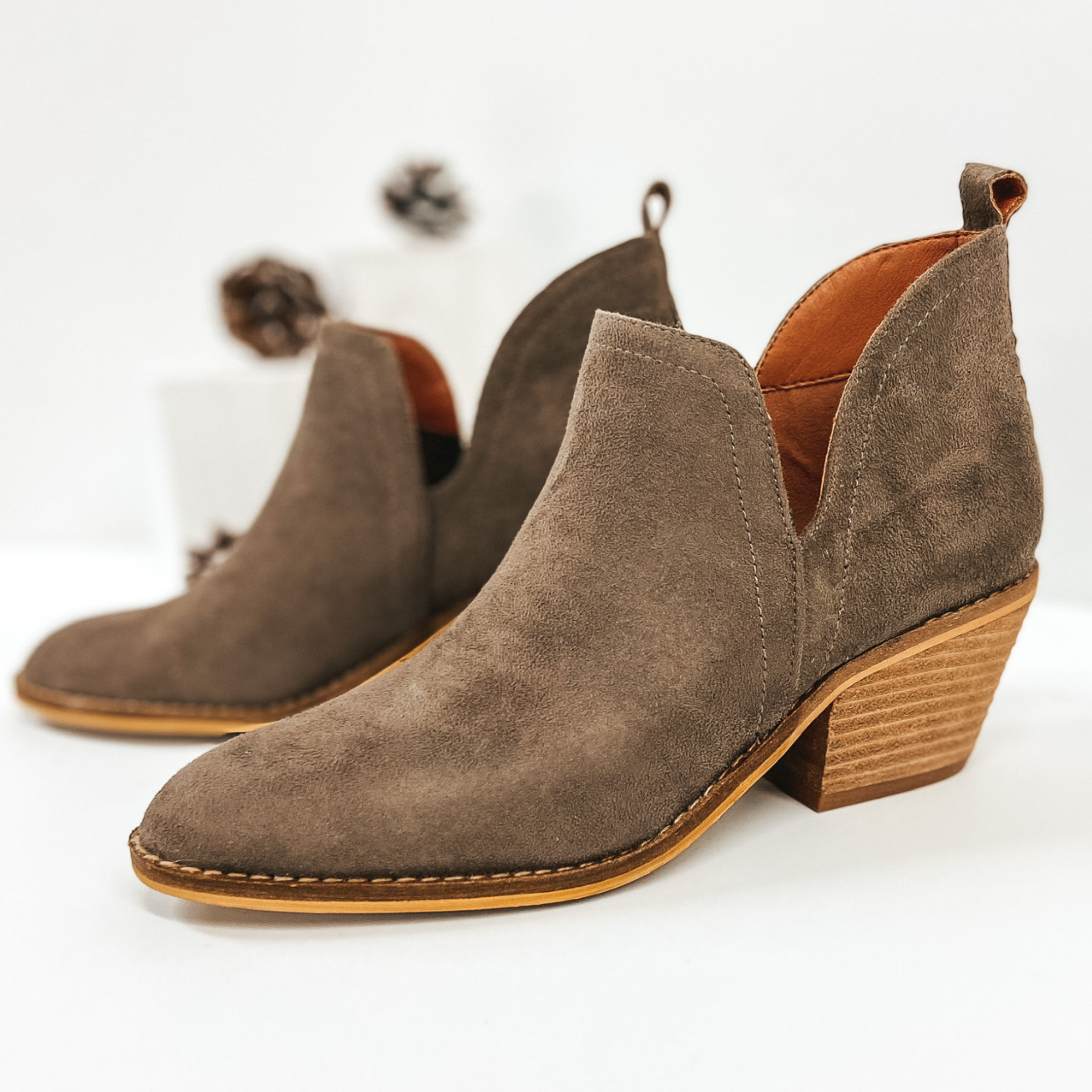 Taupe Suede booties with ankle slits. Pictured on white background.