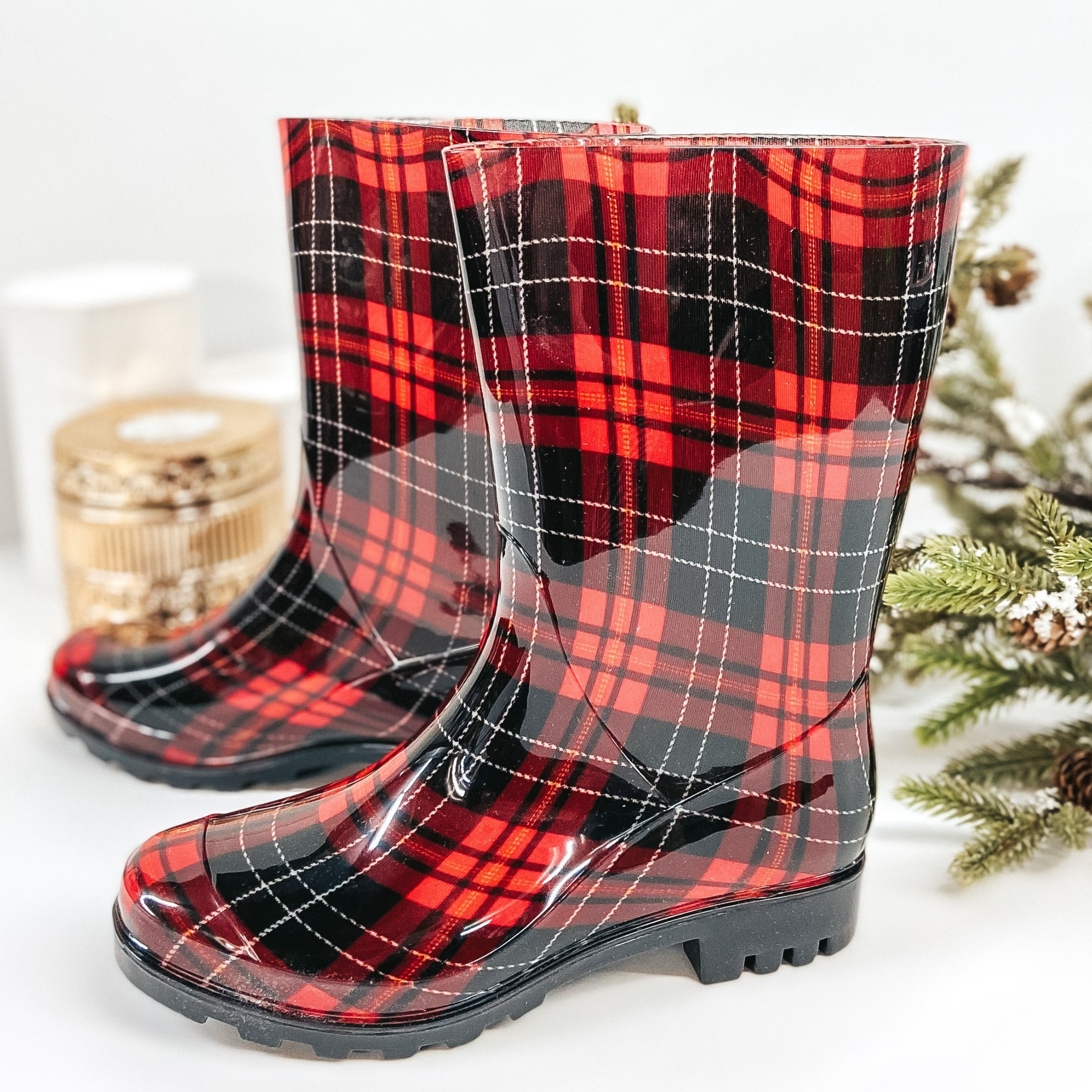 Red and black mid calf rubber boots. Pictured with garland and pinecones for season.